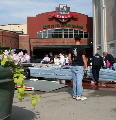Driver Bill Braack and designer Scott Hammack (far right) move the Air Force Reserve Jet Car into place ouside of Fifth Third Field in downtown Dayton, Ohio as spectators look on. (U.S. Air Force Reserve photo by 1Lt. Erica Donahoe)
