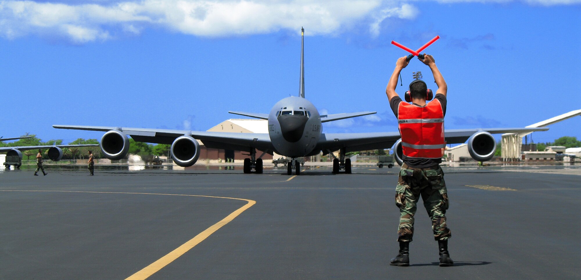 Staff Sgt. Kristian Miraflor marshals a KC-135 Stratotanker for takeoff from Hickam Air Force Base, Hawaii, on Thursday, July 27. Sergeant Miraflor is assigned to the Hawaii Air National Guard's 154th Aircraft Maintenance Squadron. (U.S. Air Force photo/Tech. Sgt. Chris Vadnais)