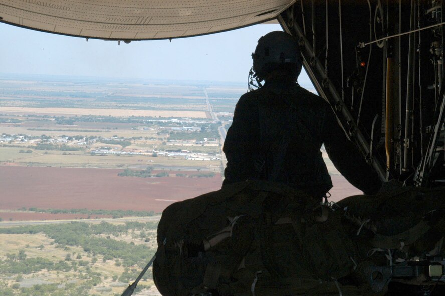 Senior Airman Jesse Morey, 39th Airlift Squadron C-130 loadmaster, watches as cargo is dropped onto the Marion drop zone Monday during a tactical flying mission here.                                