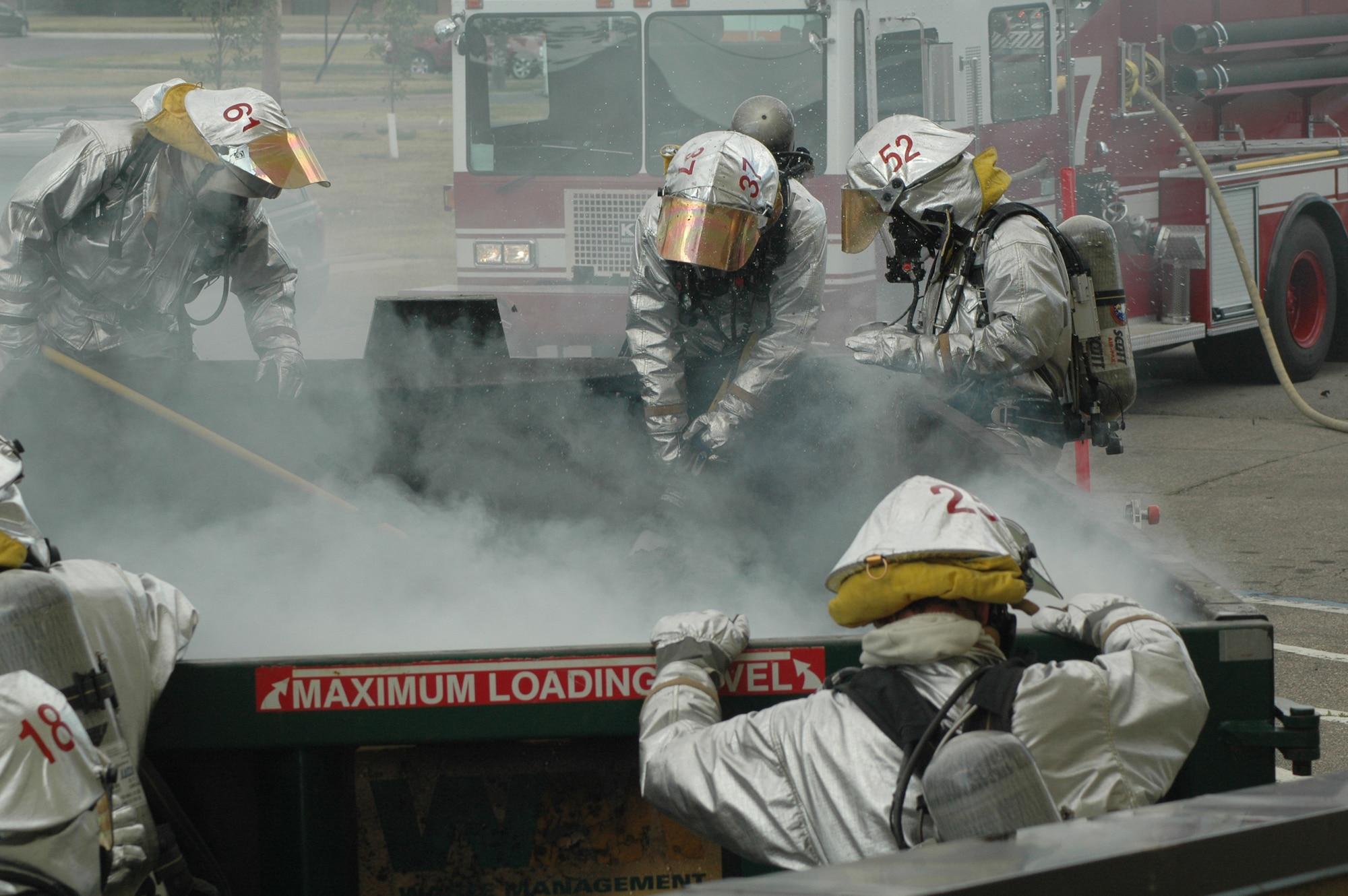 MINOT AIR FORCE BASE, N.D. -- Airmen from the 5th Civil Engineer Squadron fire protection flight, extinguish a fire in a trash dumpster in front of the PRIDE building here July 21. Airmen responded to the fire within one minute after receiving the 911 call. (U.S. Air Force photo by Capt. James Breessendorf.)