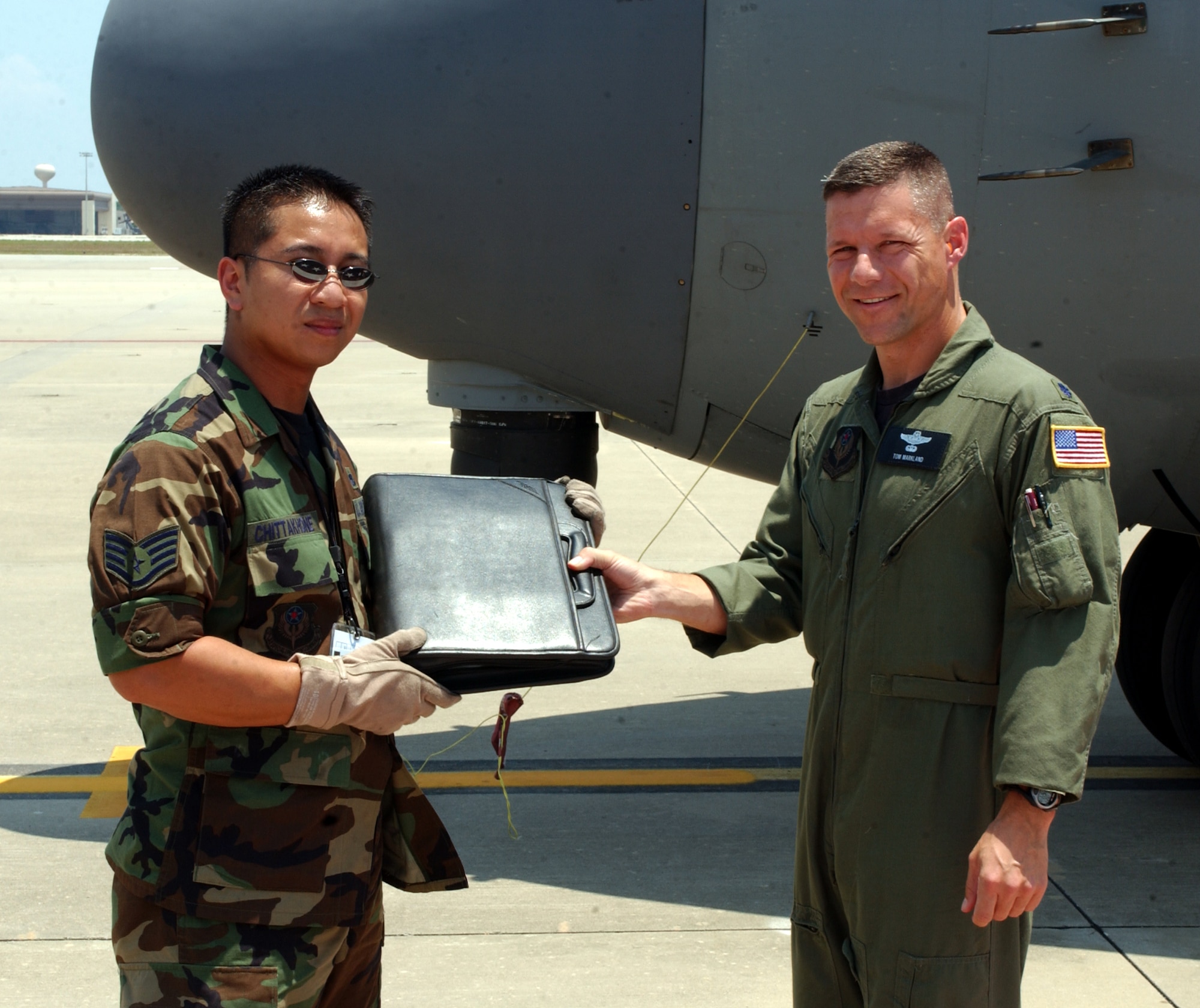 Sergeant Somkit Chittakone receives the maintenance logbook from Lt. Col. Tom Markland, Detachment 2, 16th Operations Group.  (U.S. Air Force Photograph by Senior Airman Andy Kin)