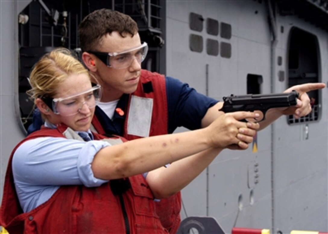 U.S. Navy Petty Officer 3rd Class Ricky Spooner instructs Seaman Apprentice Ashley Wise on proper weapons handling aboard the amphibious assault ship USS Wasp (LHD 1) as the ship operates in the Atlantic Ocean on July 22, 2006.  