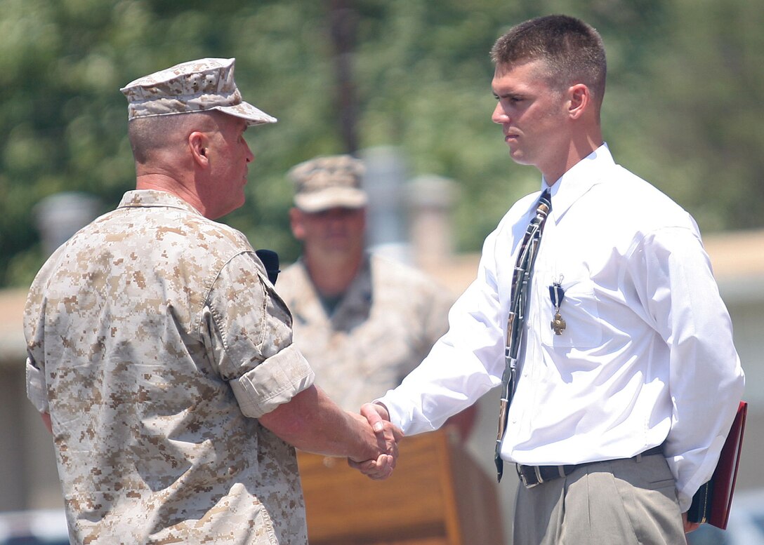 Lt. Gen. John F. Sattler, commanding general of the I Marine Expeditionary Force, congratulates former Marine Sgt. Robert J. Mitchell on his receipt of the Navy Cross during a ceremony aboard Camp Pendleton, Calif., July 28, 2006.  Mitchell, who was wounded four times during his two tours in Iraq, received the medal, the nation's second-highest award for battlefield heroism, in recognition of his actions during the battle for Fallujah, Iraq in November 2004.