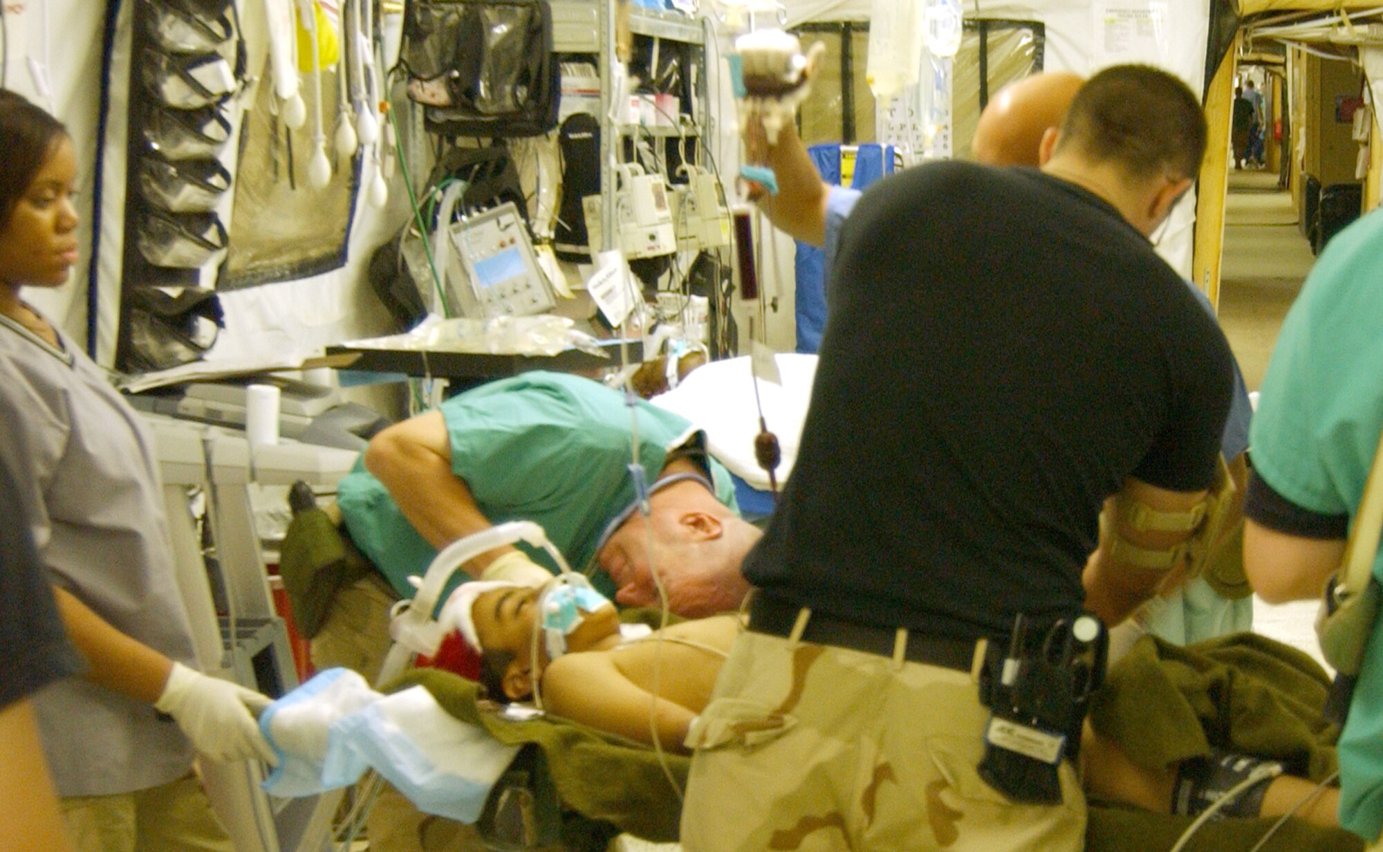 Medics work to stabilize a patient at the Air Force Theater Hospital here July 19. As the central military medical hub for Iraq, the 332d Air Expeditionary Wing averages about 750 emergency surgical operations a month and is leading new advances that may save lives. 
