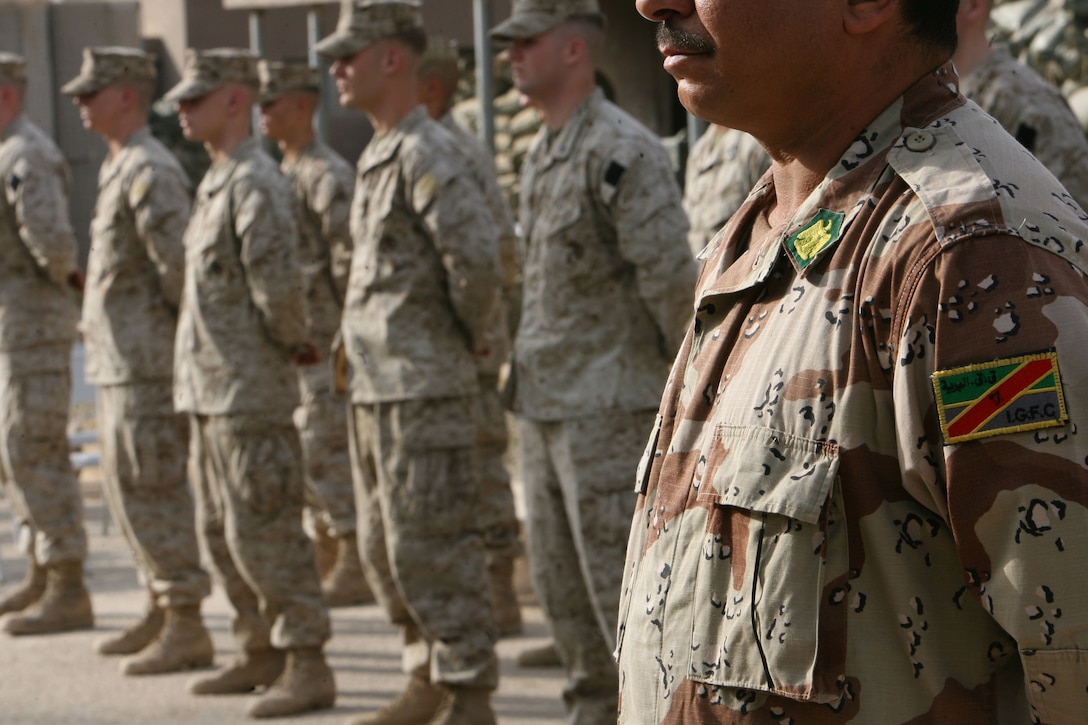 Iraqi Soldiers from the 2nd Battalion, 1st Brigade, 7th Iraqi Army stand with Marines in formation witnessing the official turn over Forward Operating Base Snake Pit in Ar Ramadi July 31.  Marines from 3rd Battalion, 8th Marine Regiment handed over control of FOB Snake Pit and surrounding battlespace to the Iraqi Army during a Transfer of Authority ceremony. 3/8 is currently deployed with I MEF (FWD) in support of Operation Iraqi Freedom in the Al Anbar province of Iraq (MNF-W) to develop the Iraqi Security Forces, facilitate the development of official rule of law through demographic government reforms, and continue the development of a market based economy centered on Iraqi reconstruction.   USMC photo by Cpl. Joseph DiGirolamo  060731-M-0008D-002