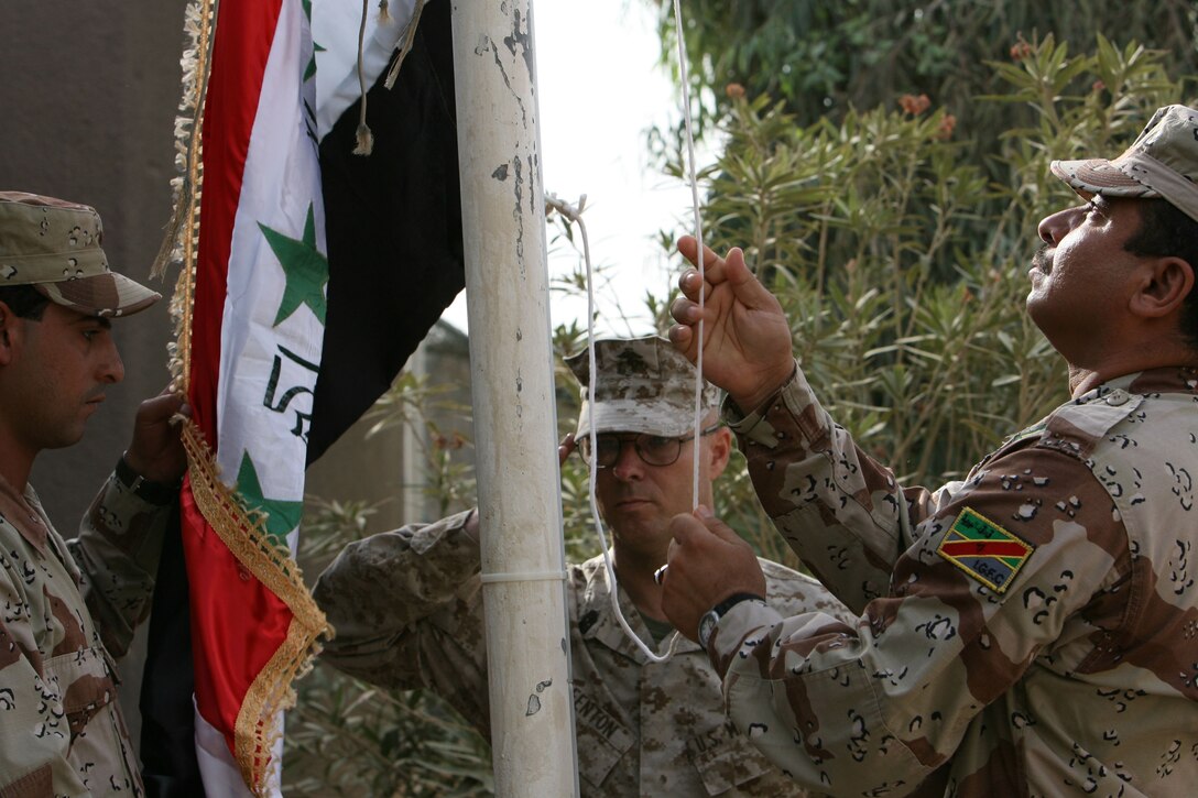 1st Sgt. Marty W. Fenton, Company L First Sergeant, salutes as Iraqi Soldier from the 2nd Battalion, 1st Brigade, 7th Iraqi Army helps raise the Iraqi Flag during the official turn over Forward Operating Base Snake Pit in Ar Ramadi July 31.  Marines from 3rd Battalion, 8th Marine Regiment handed over control of FOB Snake Pit and surrounding battlespace to the Iraqi Army during a Transfer of Authority ceremony. 3/8 is currently deployed with I MEF (FWD) in support of Operation Iraqi Freedom in the Al Anbar province of Iraq (MNF-W) to develop the Iraqi Security Forces, facilitate the development of official rule of law through demographic government reforms, and continue the development of a market based economy centered on Iraqi reconstruction.   USMC photo by Cpl. Joseph DiGirolamo  060731-M-0008D-010