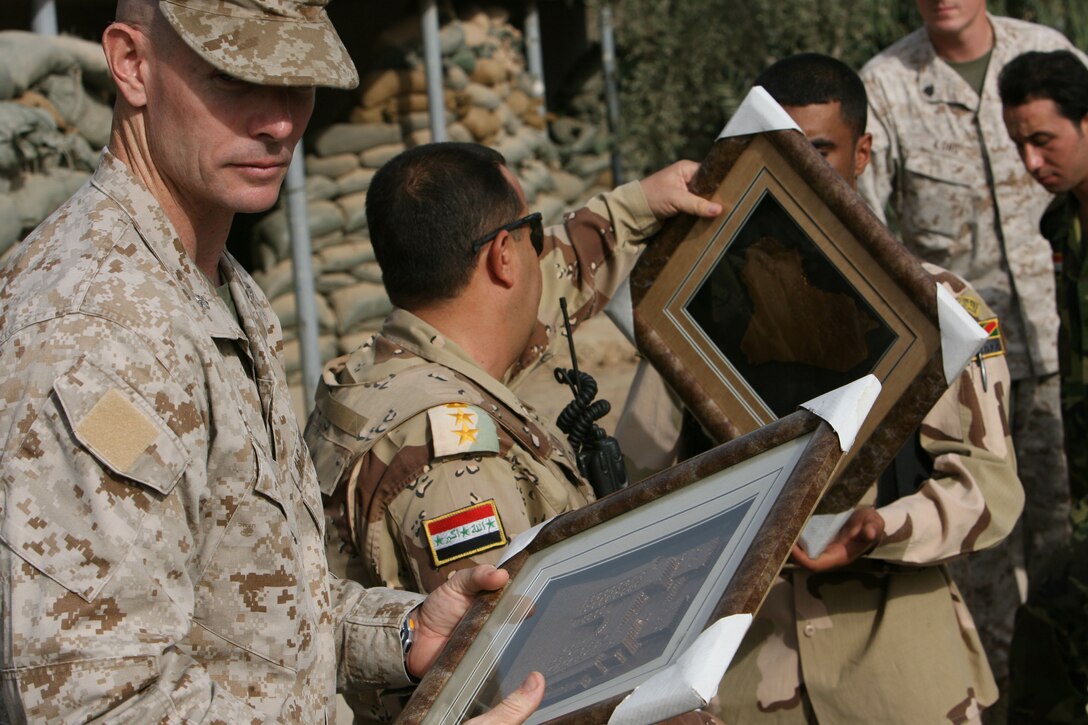 Lt. Col. Stephen M. Neary receives gifts from Iraqi Soldiers from the 2nd Battalion, 1st Brigade, 7th Iraqi Army during the official turn over Forward Operating Base Snake Pit in Ar Ramadi July 31.  Marines from 3rd Battalion, 8th Marine Regiment handed over control of FOB Snake Pit and surrounding battlespace to the Iraqi Army during a Transfer of Authority ceremony. 3/8 is currently deployed with I MEF (FWD) in support of Operation Iraqi Freedom in the Al Anbar province of Iraq (MNF-W) to develop the Iraqi Security Forces, facilitate the development of official rule of law through demographic government reforms, and continue the development of a market based economy centered on Iraqi reconstruction.   USMC photo by Cpl. Joseph DiGirolamo  060731-M-0008D-015