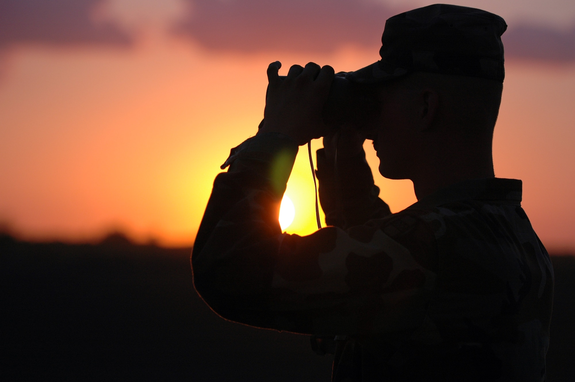 Army Spc. Alan Handy scans the horizon during sunset at San Luis, Ariz., on July 30. Soldiers and Airmen from the North Carolina National Guard are deployed in support of Operation Jump Start. Airmen are providing support for annual training by guardsmen who are working with U.S. Customs and Border Protection. (U.S. Air Force photo/Tech. Sgt. Brian E. Christiansen)
