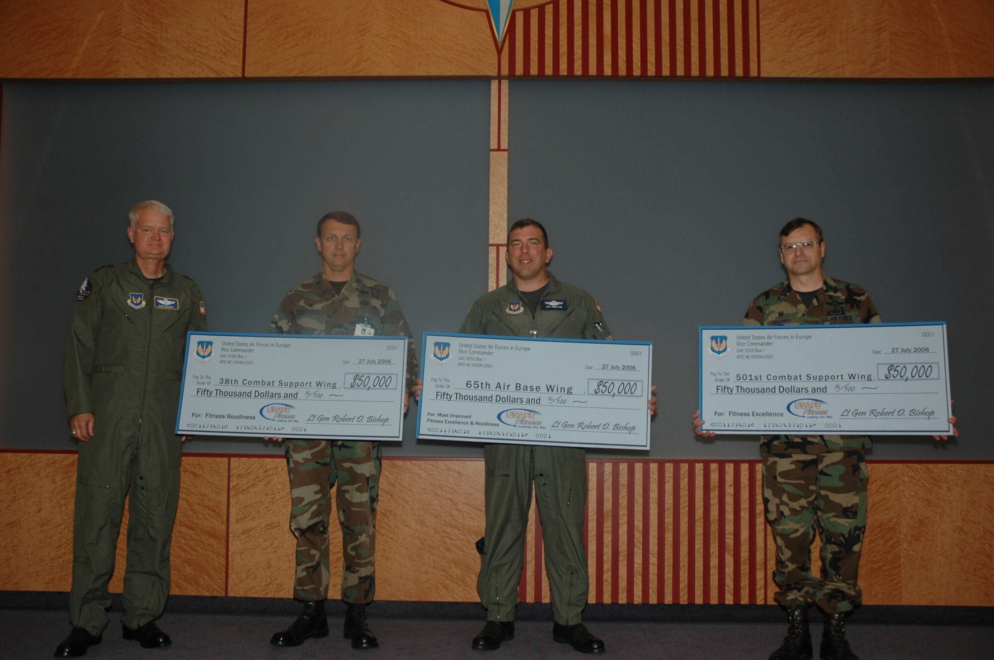 Lt. Gen. Rod Bishop (left), U.S. Air Forces in Europe vice commander, stands with winners of the USAFE FitWing Challenge competition. To the right of General Bishop, the winners are: Col. Earl Matthews, commander of 38th Combat Support Wing at Ramstein Air Base, Germany; Col. Robert Winston, commander of the 65th Air Base Wing at Lajes Field, Azores; and Col. Blake Lindner, commander of the 501st Combat Support Wing at Royal Air Force Mildenhall, England. Each wing was presented a check for $50,000 to be used toward fitness program improvements or equipment purchases. (U.S. Air Force photo/Master Sgt. Chuck Roberts)
