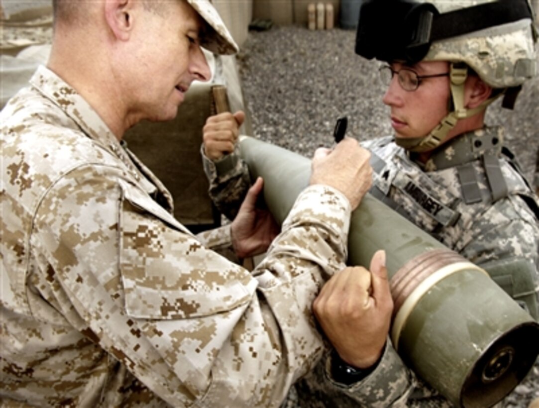 Chairman of the Joint Chiefs of Staff U.S. Marine Gen. Peter Pace signs a message on a munition, after seeing a howitzer demo from the 4th Brigade, 25th Field Artillery Regiment unit in Camp Salerno, Afghanistan, July 28, 2006. 