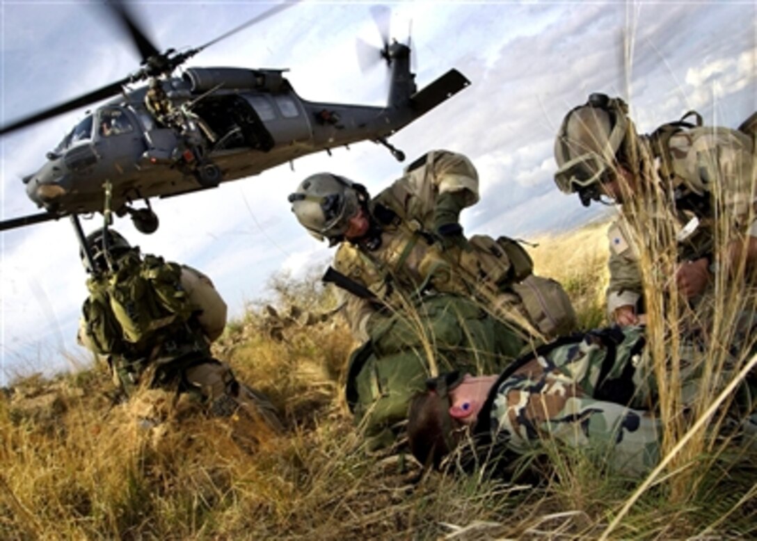 U.S. Air Force pararescuemen from the 48th and 58th Rescue Squadrons prepare to load a mock patient into an HH-60 Pave Hawk helicopter during a mass casualty exercise in the Huachuca Mountains in Sierra Vista, Ariz., July 27, 2006.