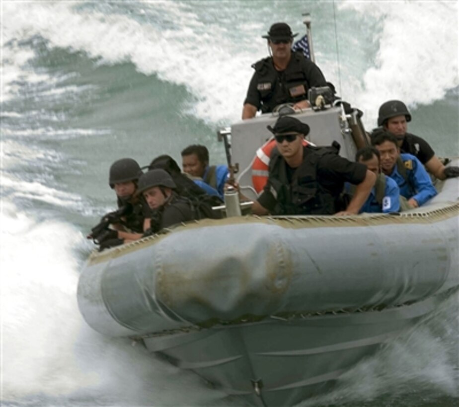 A Visit, Board, Search and Seizure Team, made up of U.S. sailors and Royal Malaysian Navy sailors, rush to the guided-missile frigate USS Crommelin in a rigid hull inflatable boat to perform a pierside boarding in the waters near Kemaman, Malaysia, during exercise Cooperation Afloat Readiness and Training, July 27, 2006. 