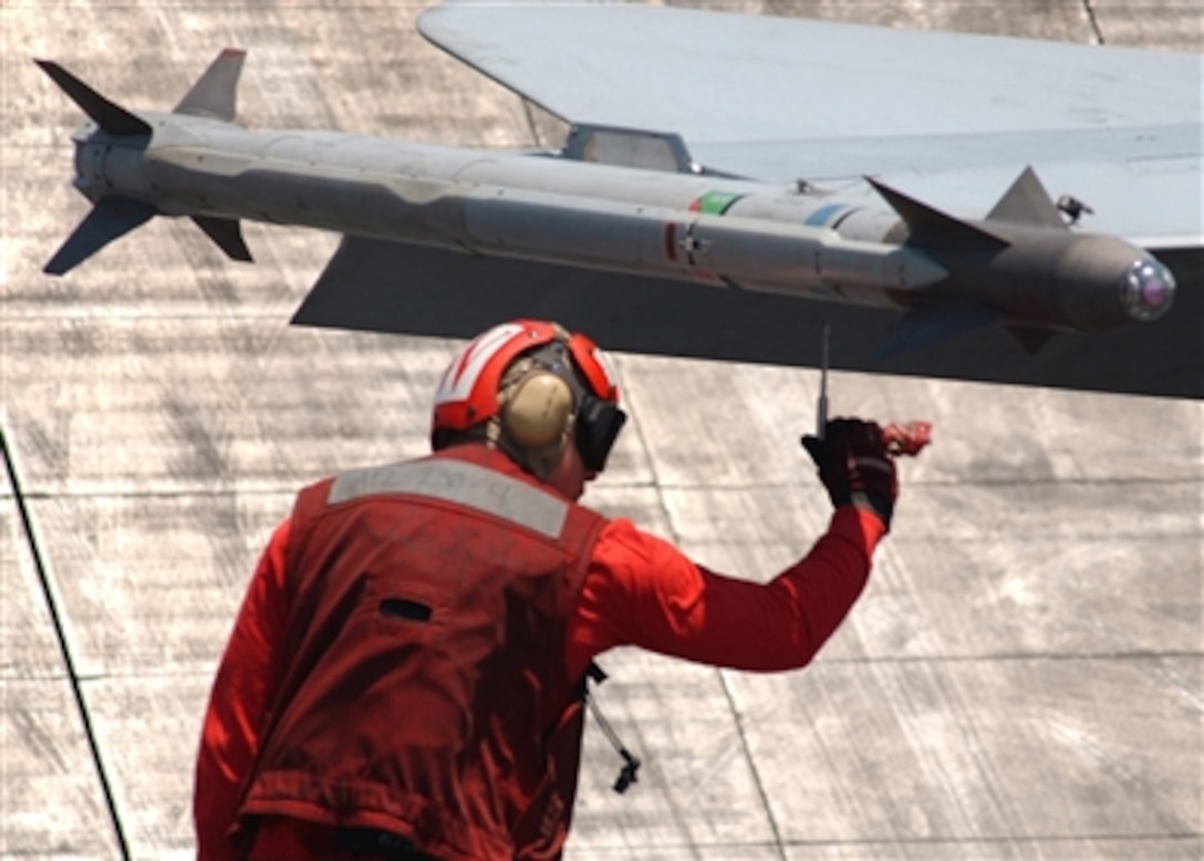 A U.S. Navy aviation ordnanceman performs final safety checks to weapons.