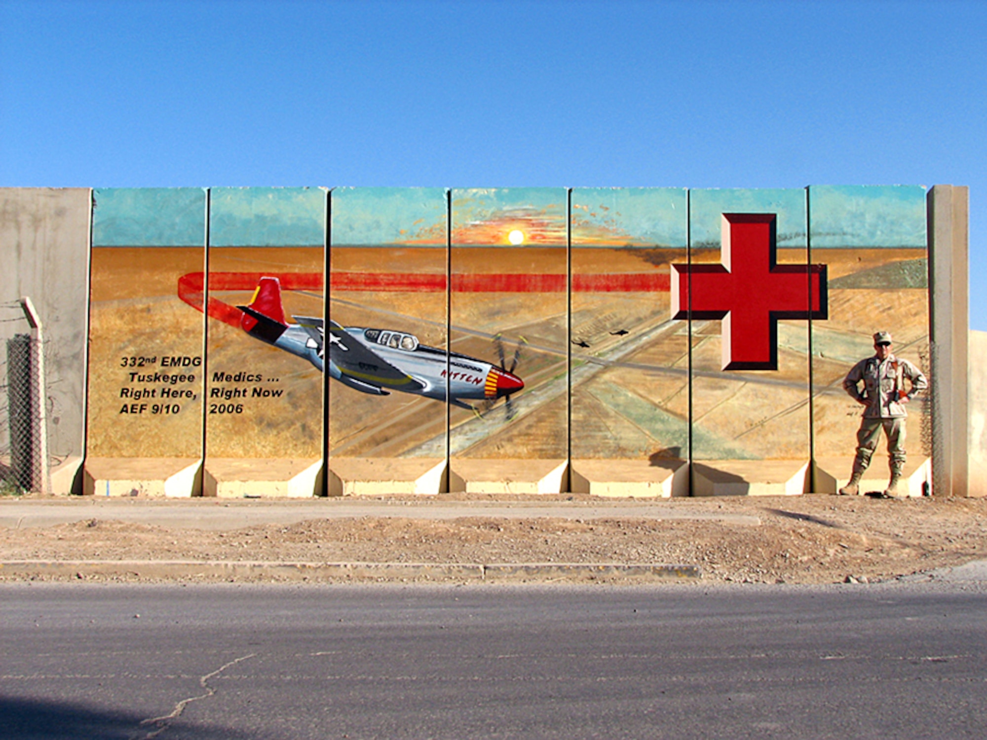 Col. Don Taylor, 332nd Expeditionary Medical Group commander at Balad Air Base, Iraq, stands in front of the Air Force Theater Hospital's "barrier art," a mural it took him more than a month to paint.  Barrier art is found throughout the base and is an expression of unit pride and esprit de corps.  His design, featuring the red-tailed P-51 Mustang, pays homage to the 332nd Air Expeditionary Wing's Tuskegee Airmen heritage.  (U.S. Air Force photo)