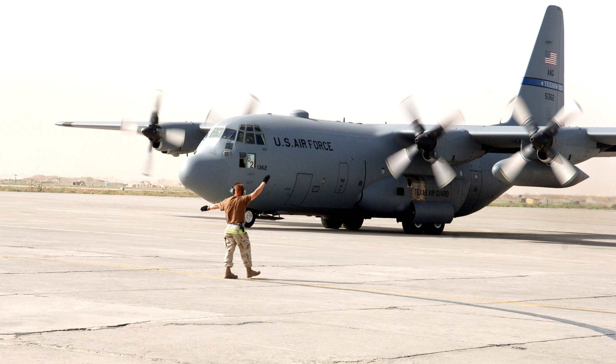 Tech. Sgt. Dale Durham marshals in a C-130 Hercules on the ramp at Bagram Air Base, Afghanistan, on Wednesday, May 31, 2006.  Sergeant Durham is with the Texas Air Natioanl Guard's 136th Airlift Wing in Fort Worth.  (U.S. Air Force photo/Master Sgt. Orville F. Desjarlais Jr.)