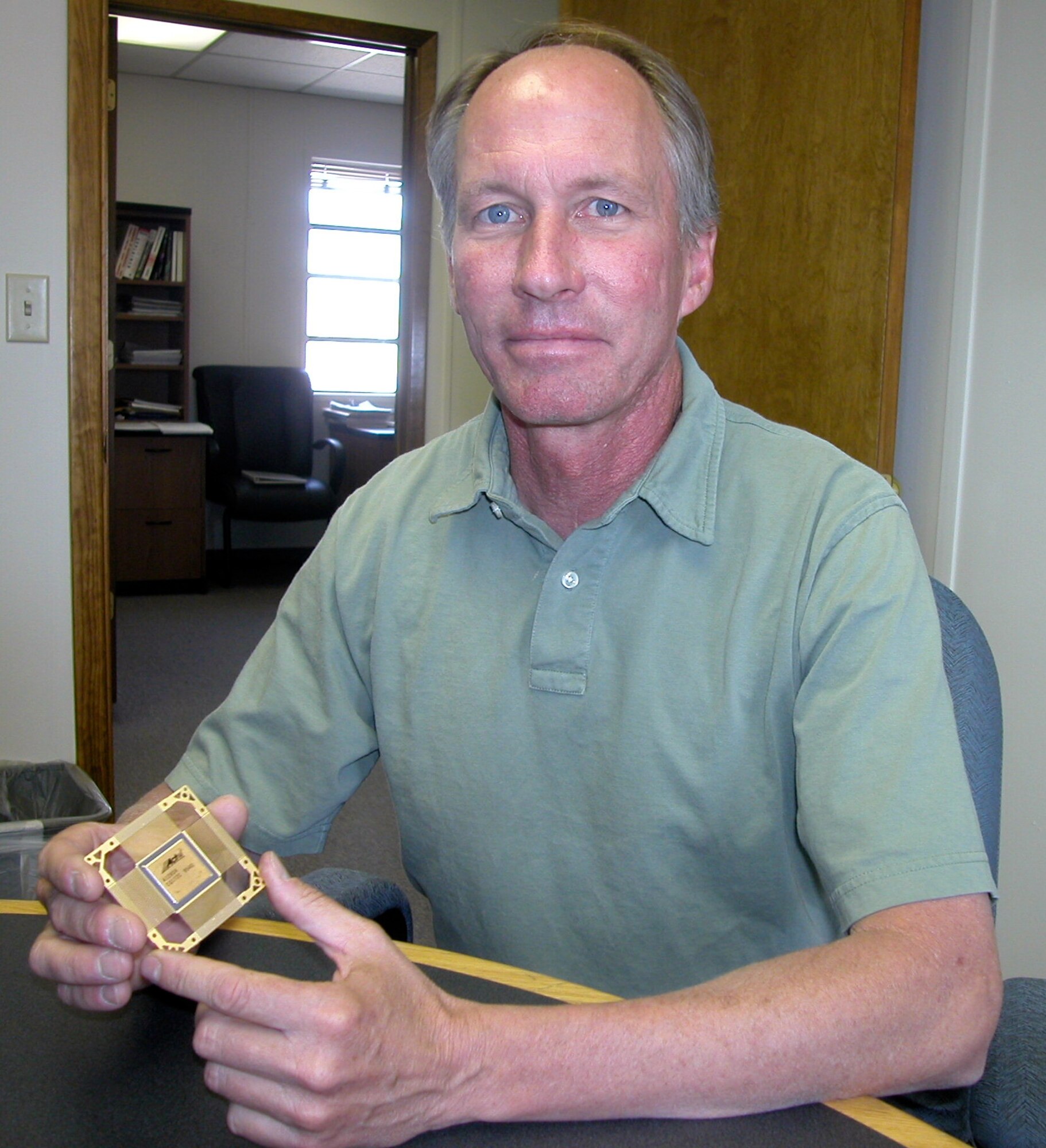 KIRTLAND AIR FORCE BASE,  N.M. — Creigh Gordon, Field Programmable Gate Array program manager, Air Force Research Laboratory's Space Vehicles Directorate, holds a copy of the small, radiation-hardened computer chip used in the Mars Pathfinder mission in 1997.  The FPGA Program is currently working with two contract companies to provide an updated version of the semiconductor device to employ in the next generation of Air Force spacecraft.  (Air Force photo by Michael P. Kleiman) 

