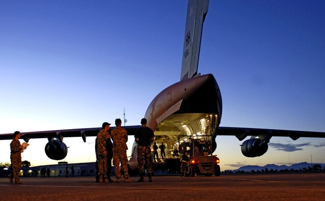 Airmen from the Australian 1st Air Terminal Squadron observe the loading of equipment onto a C-17 Globemaster III at Honiara International Airport, Solomon Islands, on Sunday, May 28, 2006. Two C-17s from the 15th Airlift Wing and Hawaii Air National Guard's 154th Wing at Hickam Air Force Base, Hawaii, are helping the Australian Defense Force reposition its forces to better support peace operations in East Timor. (U.S. Air Force photo/Tech. Sgt. Shane A. Cuomo) 
