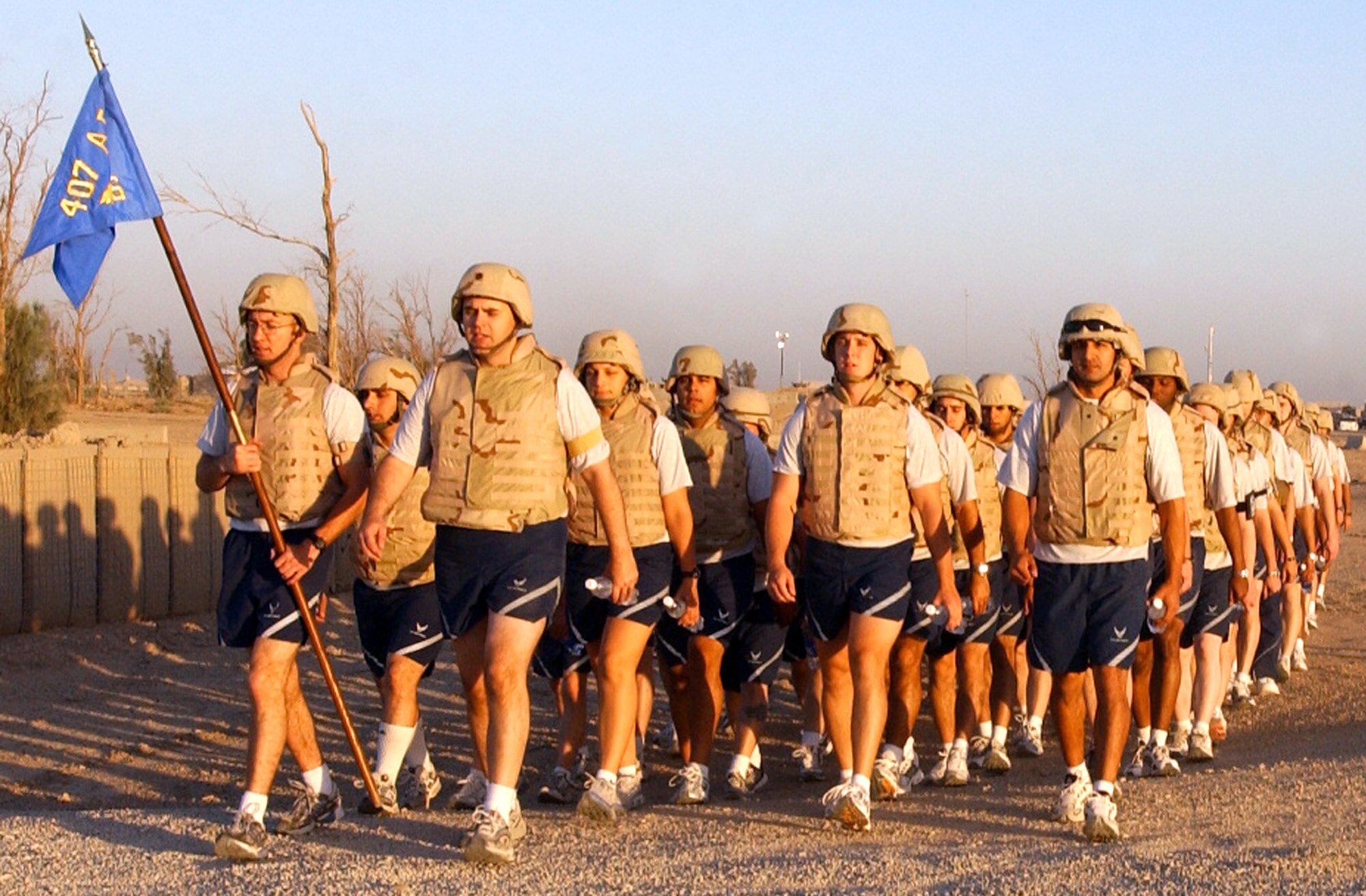 Airmen from the 407th Expeditionary Communications Squadron at Ali Base, Iraq, are led by their commander, Maj. Stephen Sweeney (front), and their first sergeant, Master Sgt. Randy Herauf (far left), in a flight march after a morning physical training session  on Thursday, June 1, 2006. (U.S. Air Force photo/Staff Sgt. Jonathan Pomeroy)