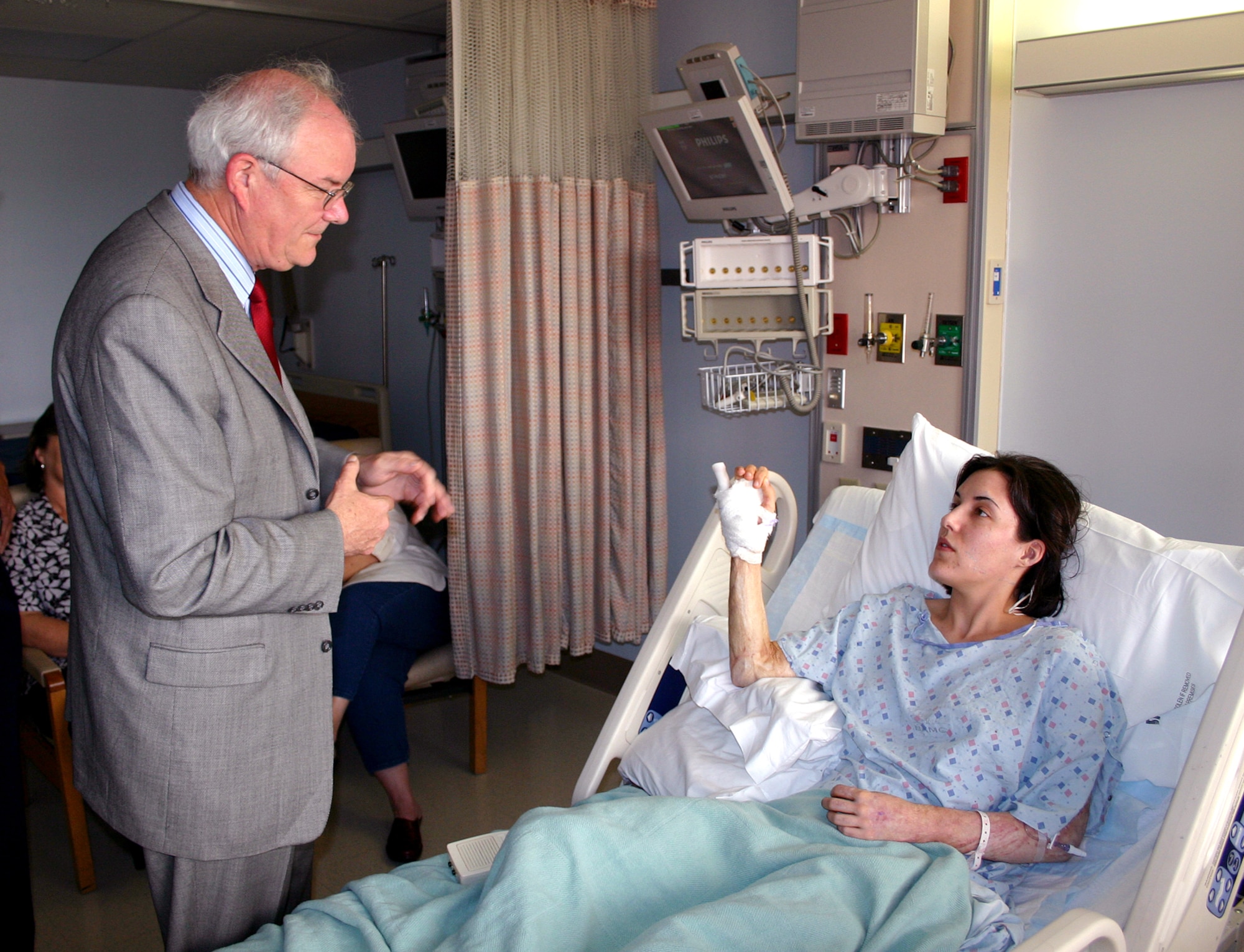 Capt. Therese Frentz explains her injuries to Secretary of the Air Force Michael W. Wynne at Brooke Army Medical Center on Thursday, June 1, 2006. Secretary Wynne was in San Antonio visiting various military installations and training sites. Captain Frentz was hospitalized for skin graft surgery this week. She was injured in October 2004 when a suicide bomber attacked a café in Baghdad's Green Zone. Her injuries included burns on 30 percent of her body and shrapnel to her knees and abdomen. (U.S. Air Force photo/2nd Lt. David Herndon)