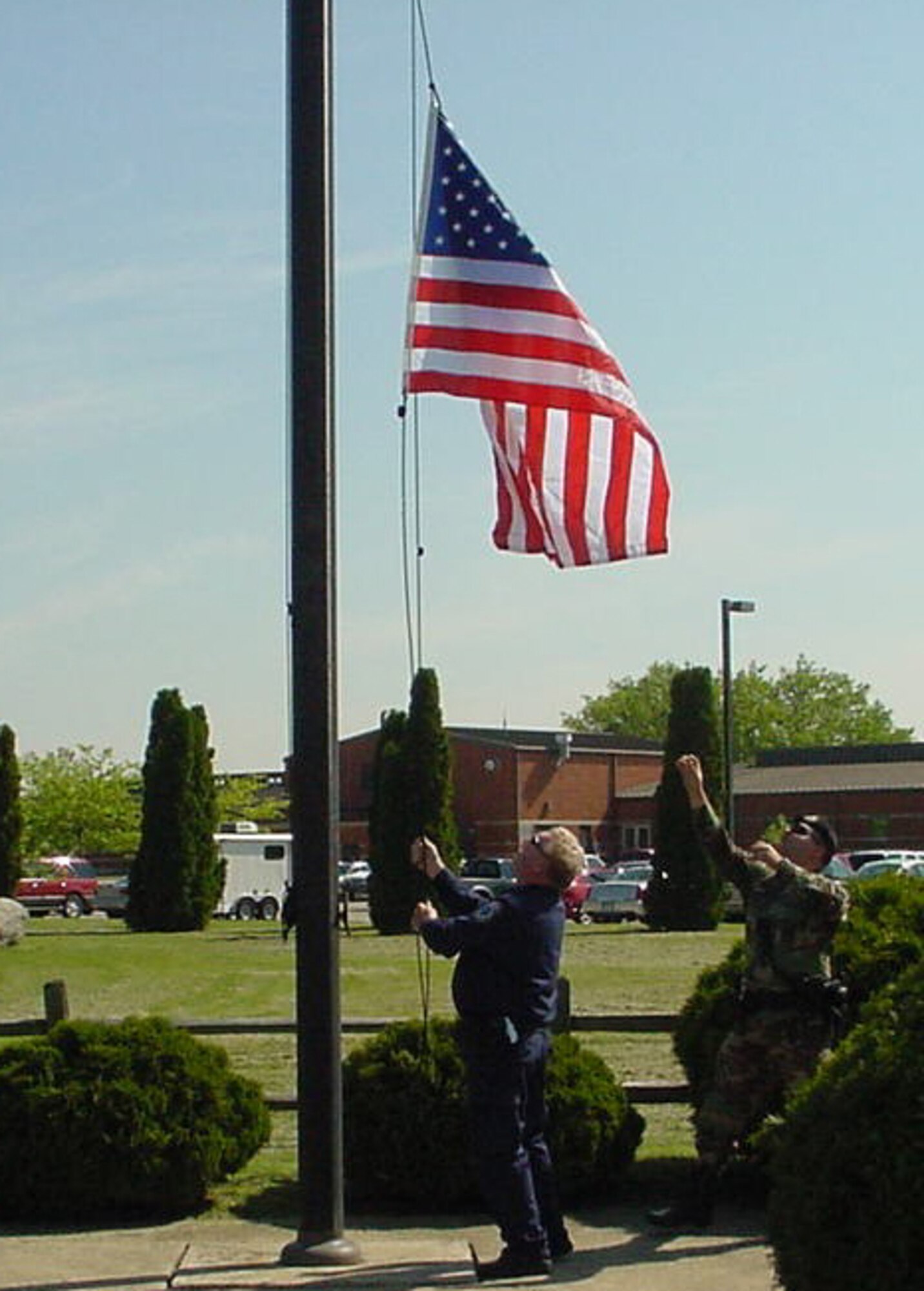Department of Defense Police Officer Kelly Frazier (left) and Staff Sgt. Adam Soultz of the 434th Security Forces Squadron lower the American flag at Grissom Air Reserve Base, Ind.  The flag was flown at Grissom as part of a special retirement project for Col. Shelia Henderson of Langely Air Force Base, Va.  (U.S. Air Force photo/Mr. Mike Ayers) 