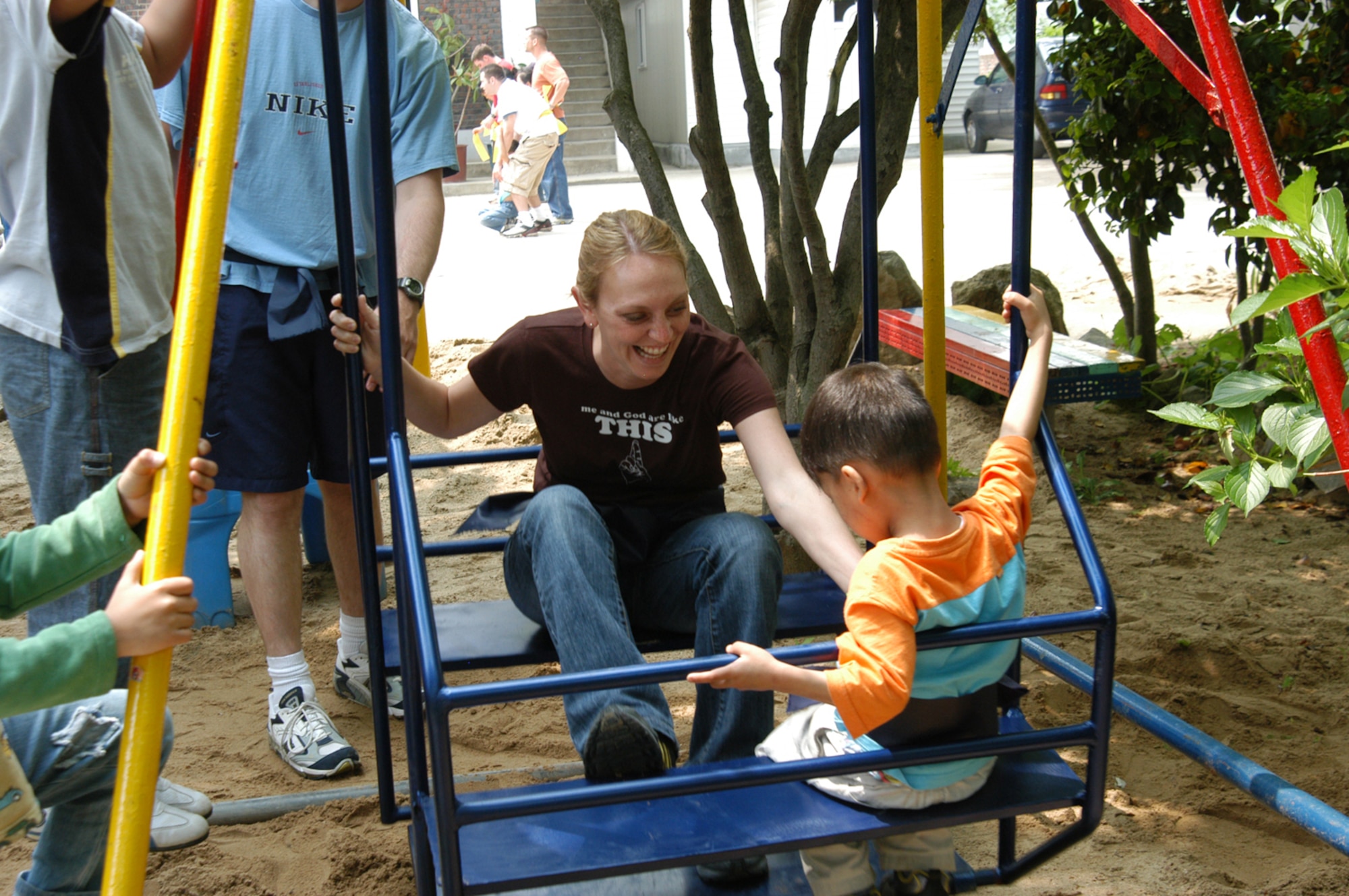 KUNSAN AIR BASE, Republic of Korea - Capt. Carrie Zeune, 8th Fighter Wing safety office, goes in for the tickle while swinging with a child from the orphanage. More than 20 Wolf Pack members donated their time for the children. (Photo by Seung Wan)                                