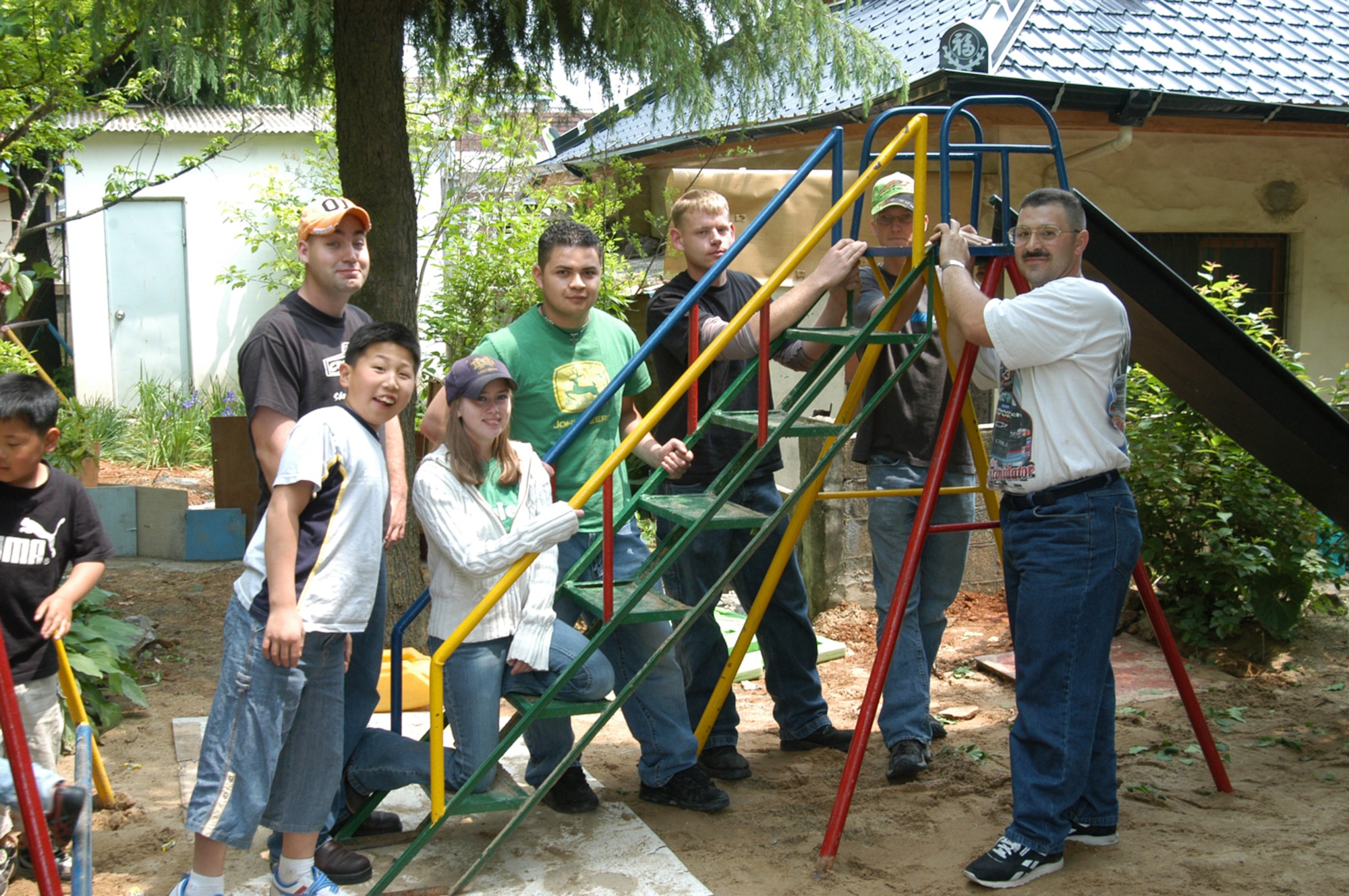 KUNSAN AIR BASE, Republic of Korea - Wolf Pack members who contributed to the refurbishment of the orphanage?s playground equipment pose after reinstalling it for the children. (Air Force photo by Senior Airman Stephen Collier)                                