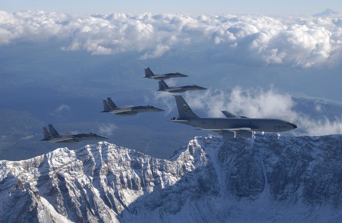 A KC-135 Stratotanker from the 939th Air Refueling Squadron, and four F-15 Eagles from the 123rd Fighter Squadron, fly over the Northwest Cascade Mountains during a mission.  Both units are assigned to the 142nd Fighter Wing located at Portland International Airport, Portland, Oregon, Oregon Air National Guard, Nov 3, 2003. (U.S. Air Force Photo/Tech. Sgt. Michael Ammons)