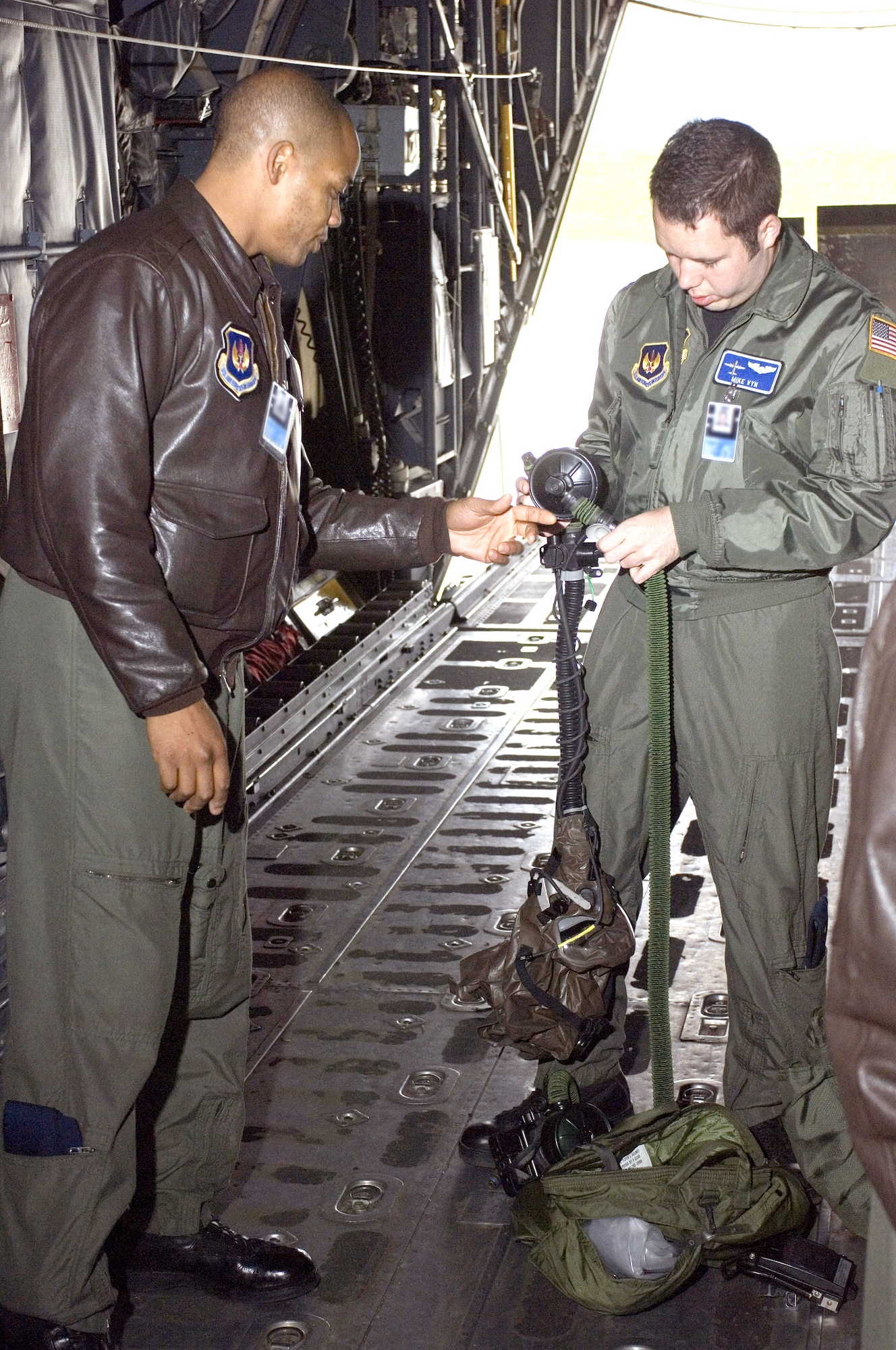 Master Sgt. Lewis Holston (left) shows an emergency respiratory protection system to 1st Lt. Mike Vyn on a C-130 Hercules at Ramstein Air Base, Germany, on Thursday, June 1, 2006. The Airmen are assigned to the 37th Airlift Squadron at Ramstein, and were training in egress procedures while wearing the protective system. (U.S. Air Force photo/Master Sgt. John E. Lasky)