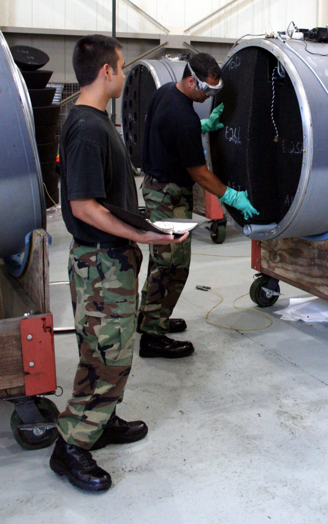 (Left) Airmen 1st Class Jeremy Macomber and Senior Airman Matthew Mendiola, 16th Component Maintenance Squadron, inspect a fuel tank from one of the AC-130U Gunship as part of the operational readiness inspection.