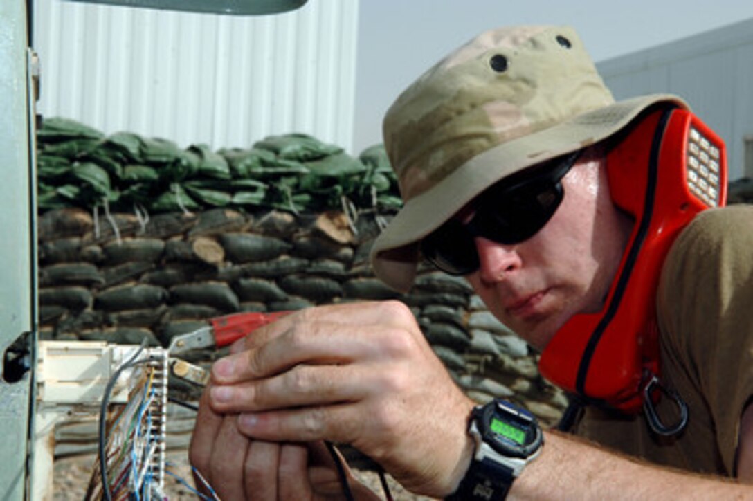 Senior Airman Robert Guyton, U.S. Air Force, uses alligator clamps to check the phone line connectivity on a 66 block in the hospital housing area of Balad Air Base, Iraq, on May 31, 2006. Guyton is a cable maintenance antenna journeyman from the 332nd Expeditionary Communications Squadron, 332nd Air Expeditionary Wing, deployed from Kapaun Air Station, Germany. 