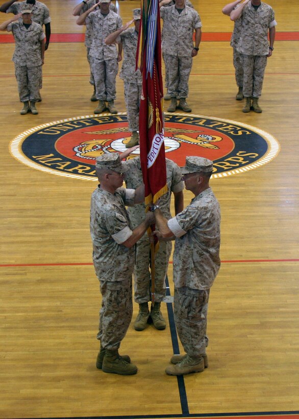 Col. Douglas Stilwell receives the unit colors from Col. Kenneth F. McKenzie, symbolizing the passing of command during the 22nd Marine Expeditionary Unit's change of command ceremony held in Goettge Memorial Field House June 2, 2006.