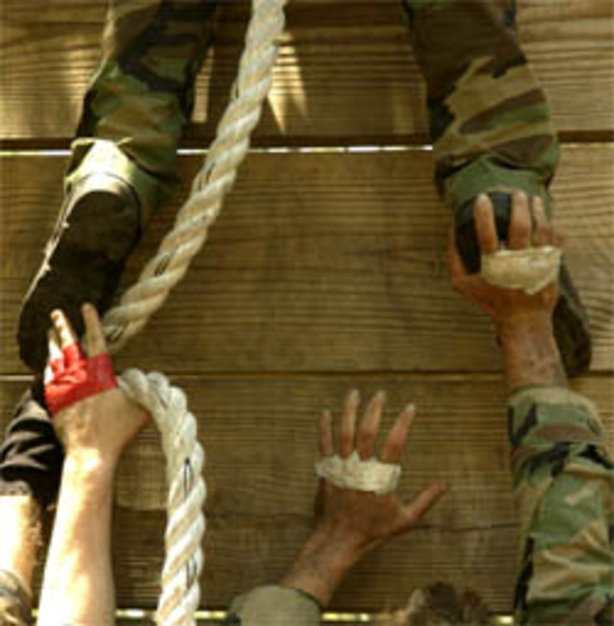 A team of competitors help someone over a wall as part of the Dragon Challenge compation in Avon Park FL. May 21, 2006.  Dragon Challenge is a 18th Air Support Operations Group competition the challenges battlefield Airman both mentally and physically and helps prepare them and test their skills for the stresses of combat.  (US Air Force Photo by Tech Sgt Jeromy K. Cross)