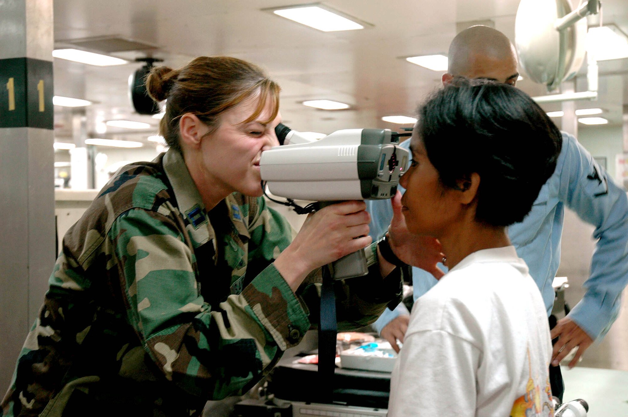 Capt. Jennifer Owen conducts an eye exam for a Filipina aboard the U.S. Navy hospital ship, USNS Mercy, while anchored off the city of Zamboanga, Philippines, on Friday, May 26, 2006. The crew is conducting humanitarian and civic assistance in South and Southeast Asia and the Pacific Islands. Captain Owen is one of several Air Force medical professionals on the ship. (U.S. Navy photo/Photographer?s Mate 2nd Class Erika Jones) 
