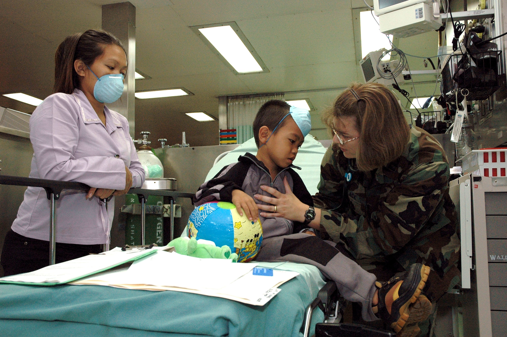 Capt. Gretchen Black comforts a patient in the casualty receiving ward aboard the U.S. Navy hospital ship, USNS Mercy, while anchored off the city of Zamboanga, Philippines, on Friday, May 26, 2006. The crew is conducting humanitarian and civic assistance in South and Southeast Asia and the Pacific Islands. Captain Black is one of several Air Force medical professionals on the ship. (U.S. Navy photo/Photographer?s Mate 3rd Class Timothy Sosa)