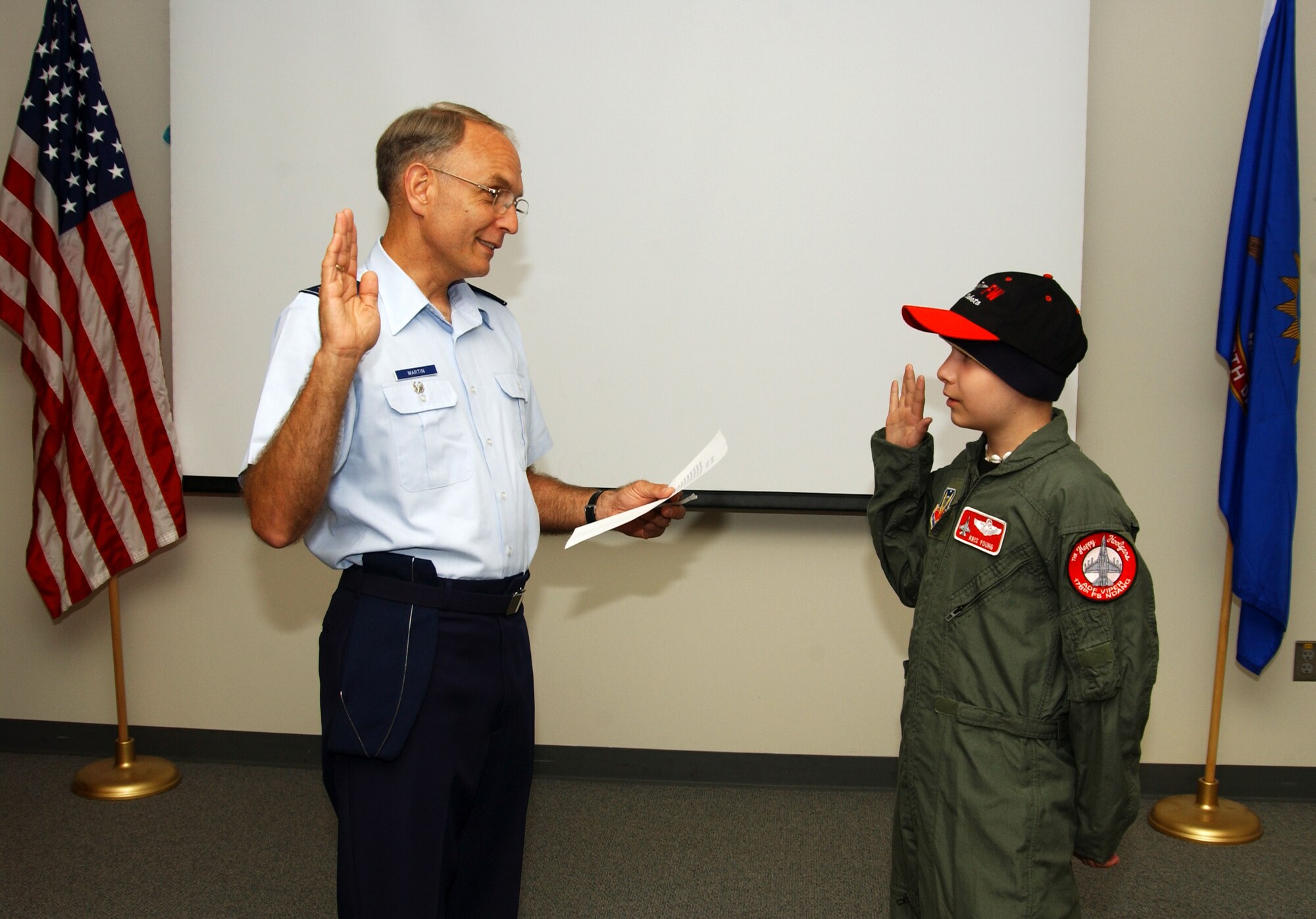 Col. Patrick Martin swears in Kris Young as a "pilot for a day" at the Air National Guard's 119th Fighter Wing in Fargo, N.D., on Friday, June 2, 2006. The pilot for a day program gives children with serious health conditions a day away from medical tests and treatments. Thirteen-year-old Kris, from West Fargo, N.D., has Burkitt's lymphoma, a type of cancer. He has two uncles in the Air Force, one in the Marines, one in the Coast Guard and one in the Army. Colonel Martin is vice commander of the 119th FW. (U.S. Air Force photo/Senior Master Sgt. David H. Lipp)