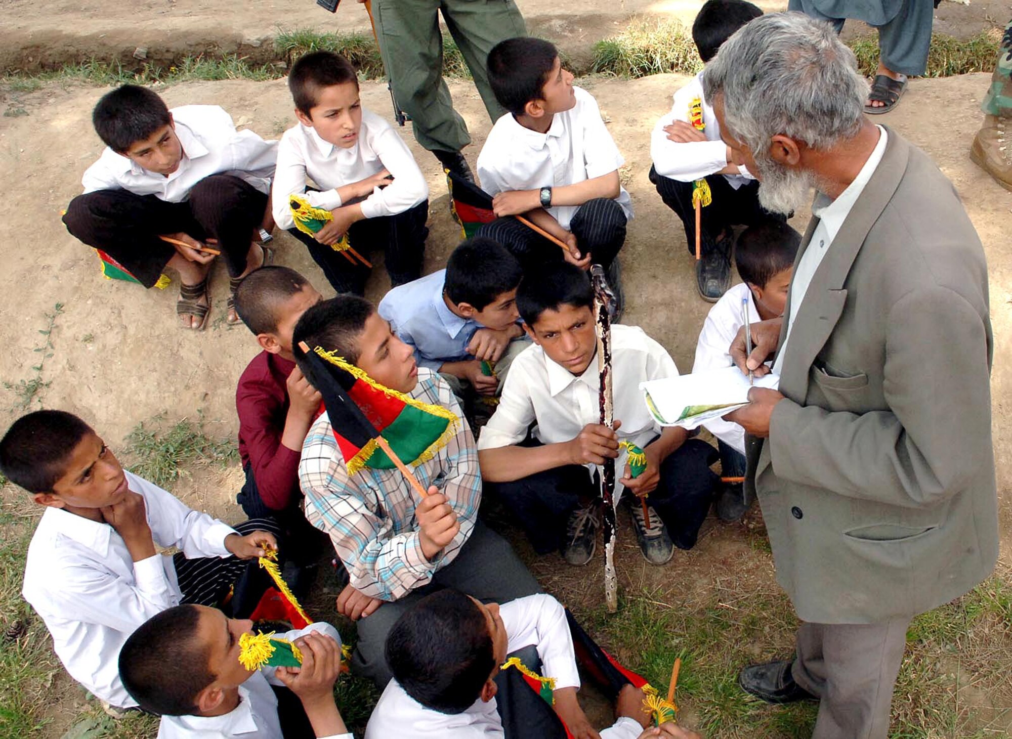 A Noman High School teacher gives last-minute instructions to the boys choir before it performs at the grand opening of its new school in Parwan Province, Afghanistan, on Friday, May 26, 2006. (U.S. Air Force photo/Master Sgt. Orville F. Desjarlais Jr.)


