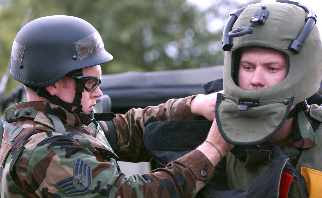 Staff Sgt. Clayton Tiemen helps Staff Sgt. Justin Surran gear up in a bomb suit at Aviano Air Base, Italy, on Tuesday, June 6, 2006, during a Local Salty Nation training exercise. The heavy-duty Kevlar suit weighs 70 pounds and is used to protect explosive ordnance disposal troops. The NCOs are assigned to the 31st Civil Engineer Squadron. (U.S. Air Force photo/Airman 1st Class Nathan Doza)