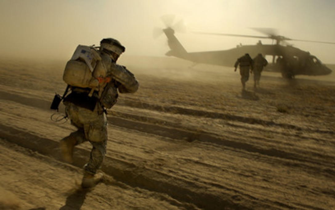 U S Army Soldiers Run Towards A UH 60 Black Hawk Helicopter 