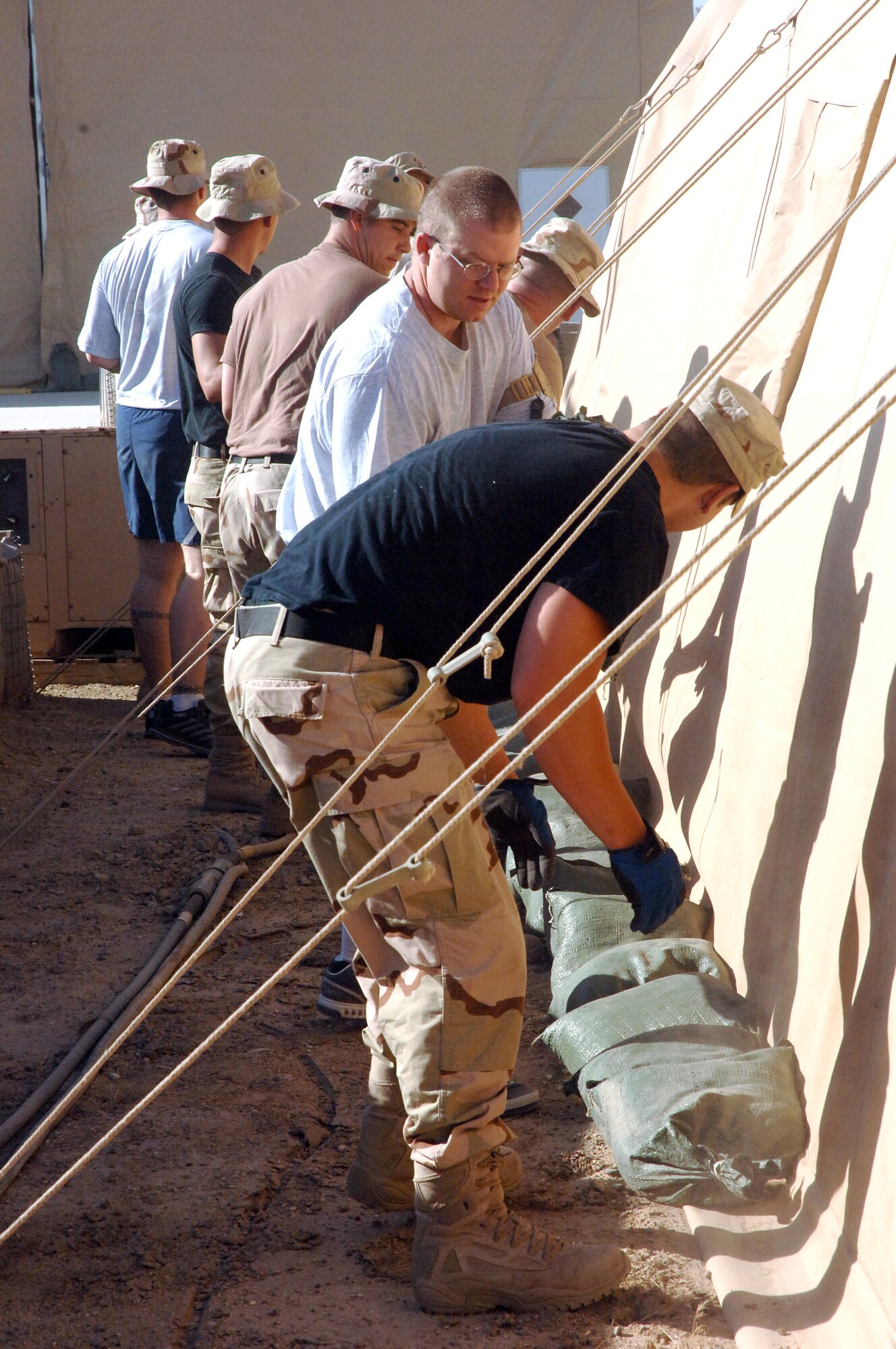 More than 50 Airmen from the 447th Air Expeditionary Group at Sather Air Base, Iraq, teamed up on Wednesday, June 7, 2006, to sandbag their recreation center to keep the cool air inside from escaping. Sather AB is located at Baghdad International Airport.  (U.S. Air Force photo/Staff Sgt. Bryan Bouchard) 