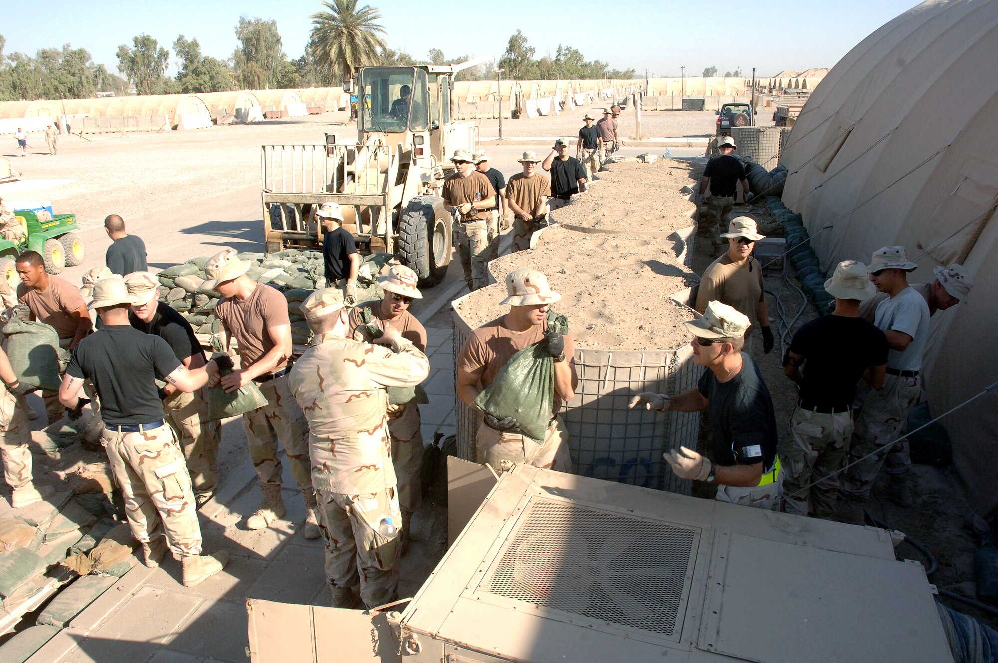 More than 50 Airmen from the 447th Air Expeditionary Group at Sather Air Base, Iraq, teamed up on Wednesday, June 7, 2006, to sandbag their recreation center to keep the cool air inside from escaping. Sather AB is located at Baghdad International Airport.  (U.S. Air Force photo/Staff Sgt. Bryan Bouchard) 