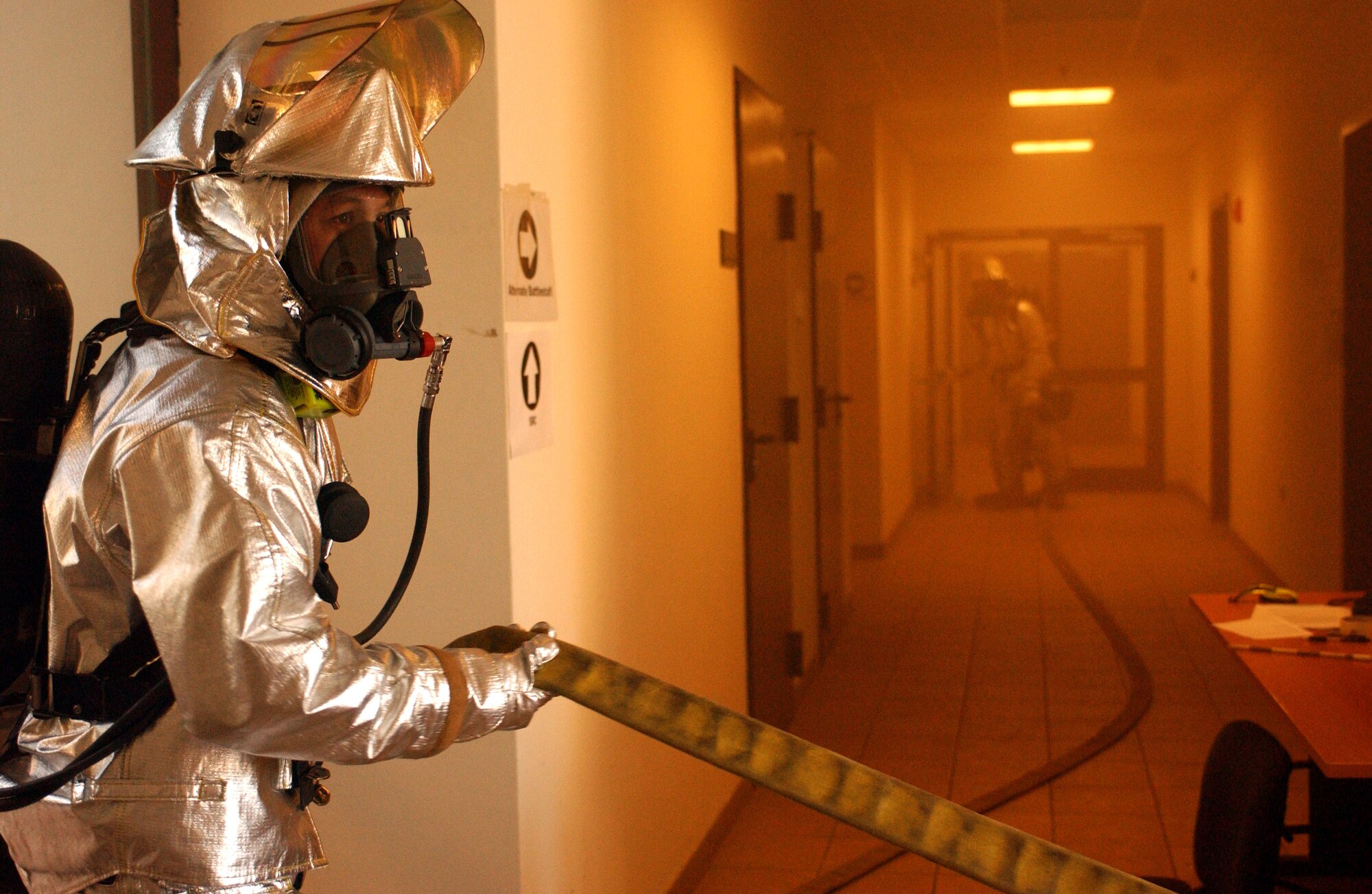 A firefighter brings a water hose into a building during a local Salty Nation exercise at Aviano Air Base, Italy, on Tuesday, June 6, 2006. The firefighter is with the 31st Fighter Wing here. The exercise runs through June 9. (U.S. Air Force photo/Staff Sgt. Bethann Caporaletti) 
