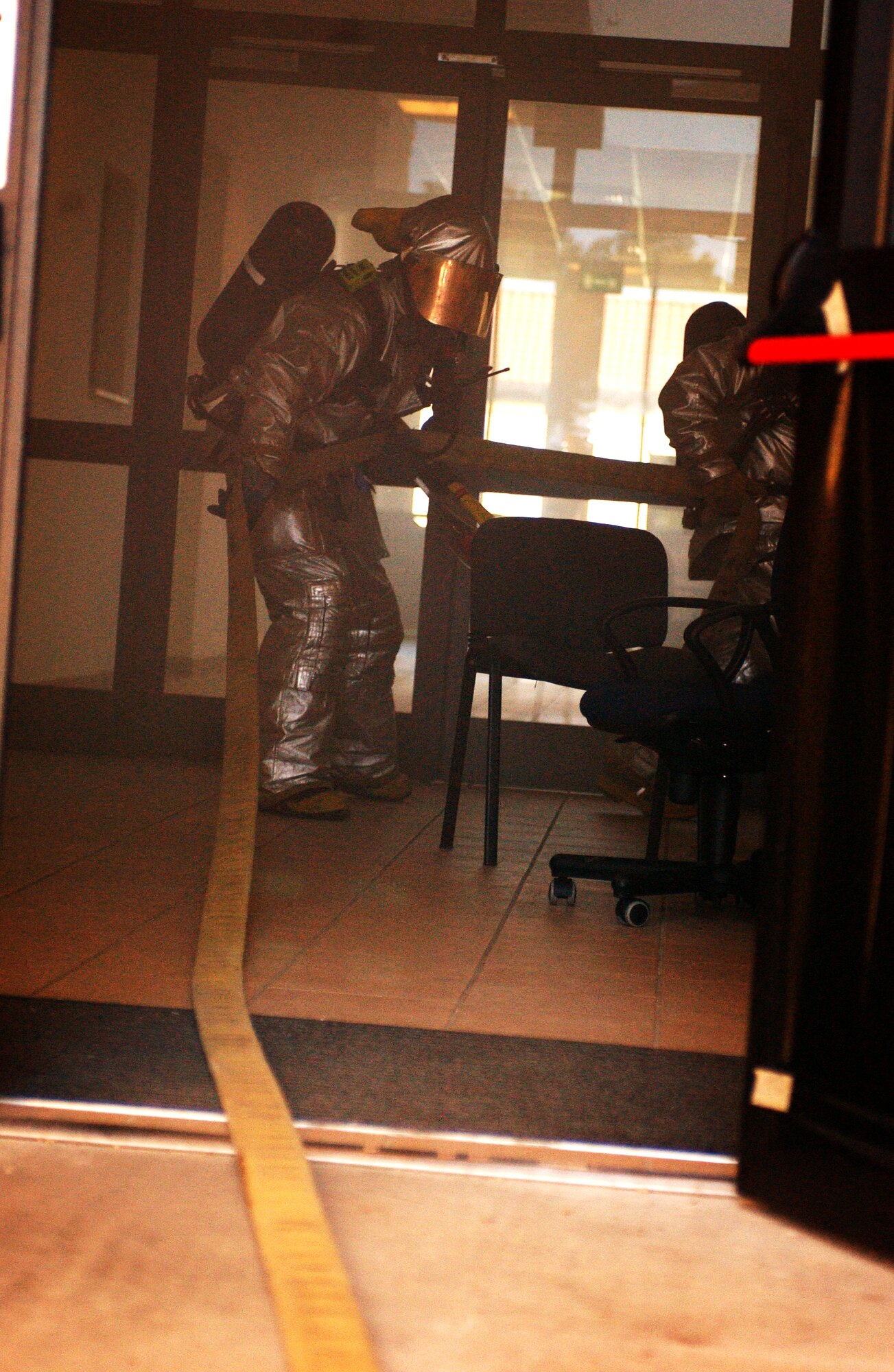 A firefighter brings a water hose into a building during a local Salty Nation exercise at Aviano Air Base, Italy, on Tuesday, June 6, 2006. The firefighter is with the 31st Fighter Wing here. The exercise runs through June 9. (U.S. Air Force photo/Staff Sgt. Bethann Caporaletti) 
