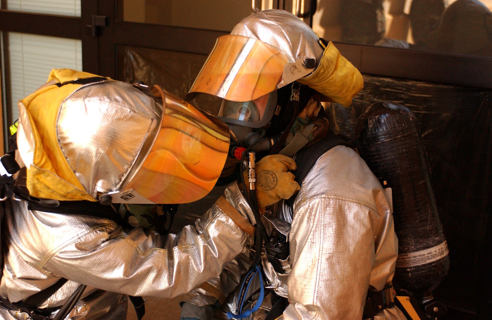 Firefighters help one another gear up before entering a building during a local Salty Nation exercise at Aviano Air Base, Italy, on Tuesday, June 6, 2006. The firefighters are with the 31st Fighter Wing here. The exercise runs through June 9. (U.S. Air Force photo/Staff Sgt. Bethann Caporaletti) 
