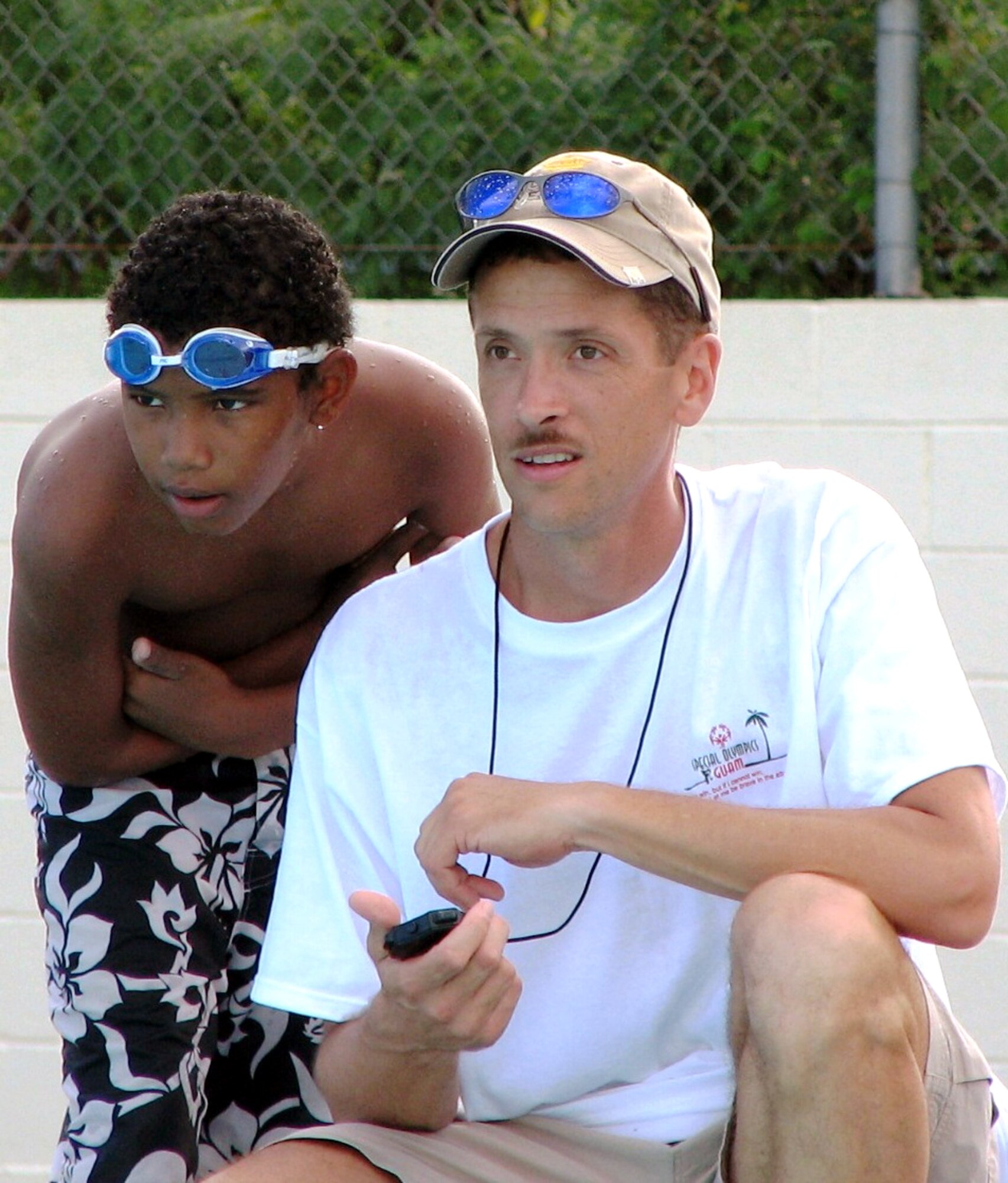 Master Sgt. Kelly Costa keeps time as athlete Isaac Belajadia watches the action at the 2006 Guam Special Olympics aquatic event on Saturday, June 3, 2006. Sergeant Costa was one of several Airmen from the 36th Expeditionary Aircraft Maintenance Squadron and 393rd Expeditionary Bomb Squadron at Andersen Air Force Base, Guam, who volunteered at the event. Sergeant Costa is assigned to the 36th EAMS. (U.S. Air Force photo/Tech. Sgt. Mikal Canfield) 
