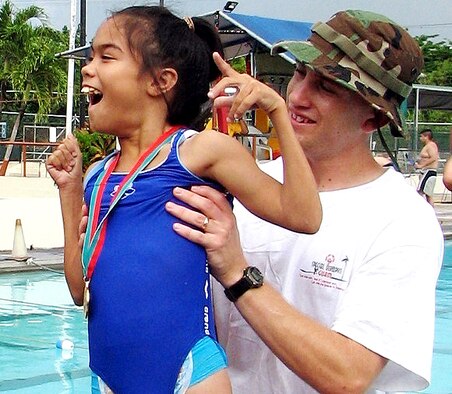 Staff Sgt. Michael Cole assists gold-medal winner Desirae Tyquiengco during the 2006 Guam Special Olympics aquatic event on Saturday, June 3, 2006. Volunteers from the 393rd Expeditionary Bomb Squadron and 36th Expeditionary Aircraft Maintenance Squadron at Andersen Air Force Base, Guam, assisted during the events, acting as official timekeepers, distributing medals and helping in other areas. Sergeant Cole is assigned to the 393rd EBS. (U.S. Air Force photo/Tech. Sgt. Mikal Canfield)