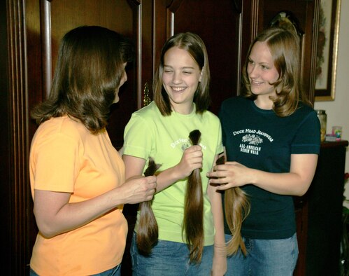 Monique McCause and her two daughters, Bethany and Tenette, compare ponytails they are donating to Locks of Love at Shaw Air Force Base, S.C., on Friday, June 2, 2006. Locks of Love is a nonprofit organization that takes donated hair and turns it into hairpieces for financially disadvantaged children who suffer hair loss from long-term medical care. Monique's husband is Tech. Sgt. Bruce McCause, 20th Component Maintenance Squadron. (U.S. Air Force photo/Tech. Sgt. Kevin Williams)