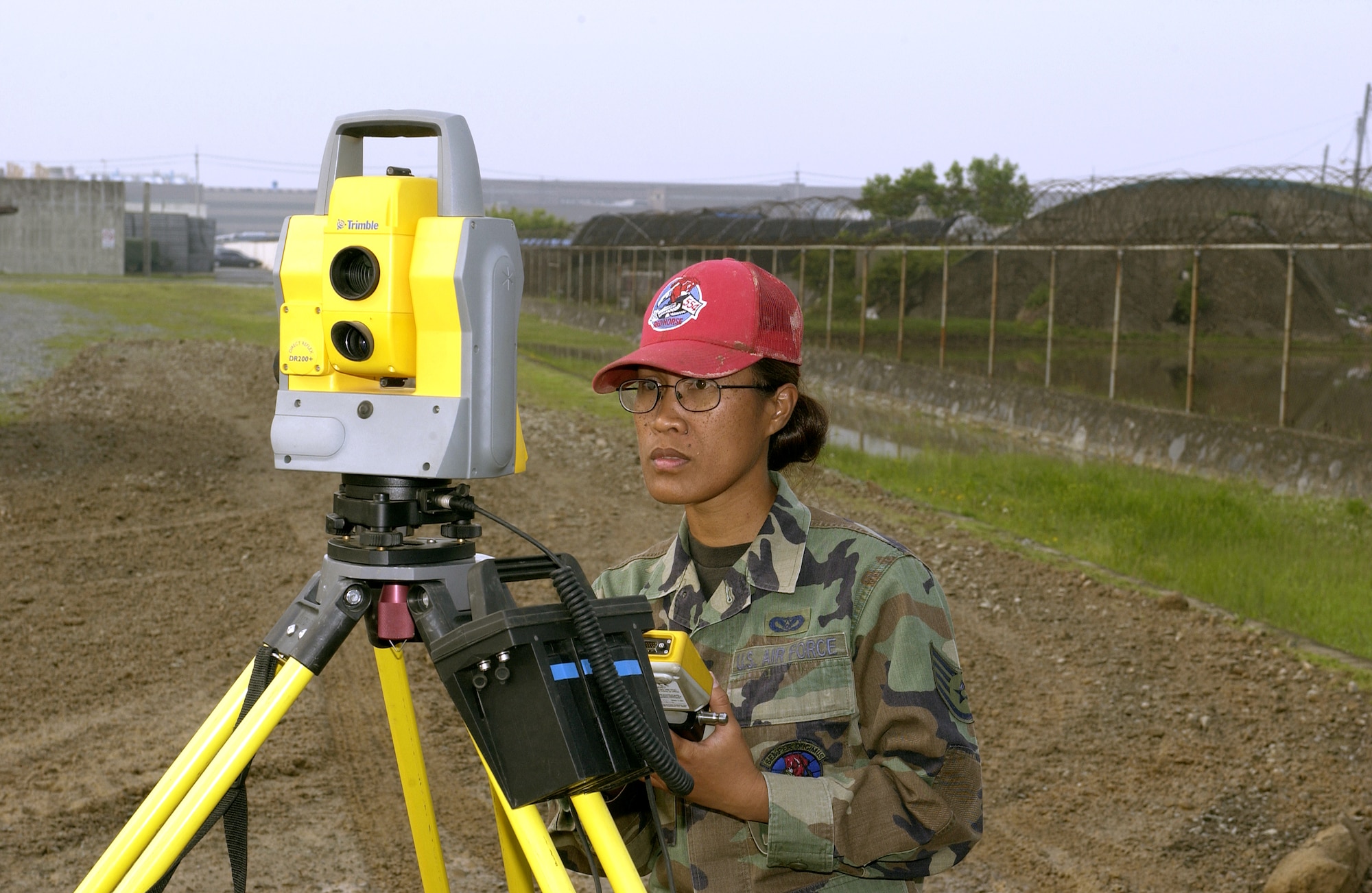 Staff Sgt. Celeste Perry uses surveying equipment at a construction site in Kimhae, South Korea, on Wednesday, May 24, 2006. Airmen from Red Horse squadrons at Nellis Air Force Base, Nev.; Barksdale AFB, La.; Andersen AFB, Guam, and Osan Air Base, South Korea, are working through September on various quality-of-life improvement projects in South Korea. Sergeant Perry is with Osan's 554th Red Horse Squadron. (U.S. Air Force photo/Tech. Sgt. Demetrius Lester) 
  