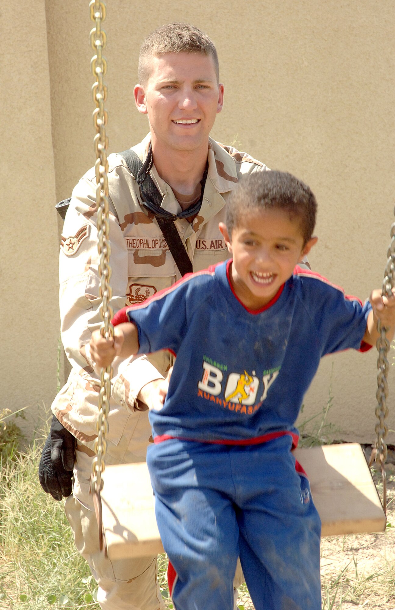 Airman 1st Class Jesse Theophilopoulos helps a four-year-old Iraqi boy swing at the Army's Civil Military Operations Center located near Sather Air Base in Baghdad. Airman Theophilopoulos said volunteering at the CMOC, which provides medical care and other needs to local Iraqi families, was a very worthwhile cause. He is deployed from McGuire.