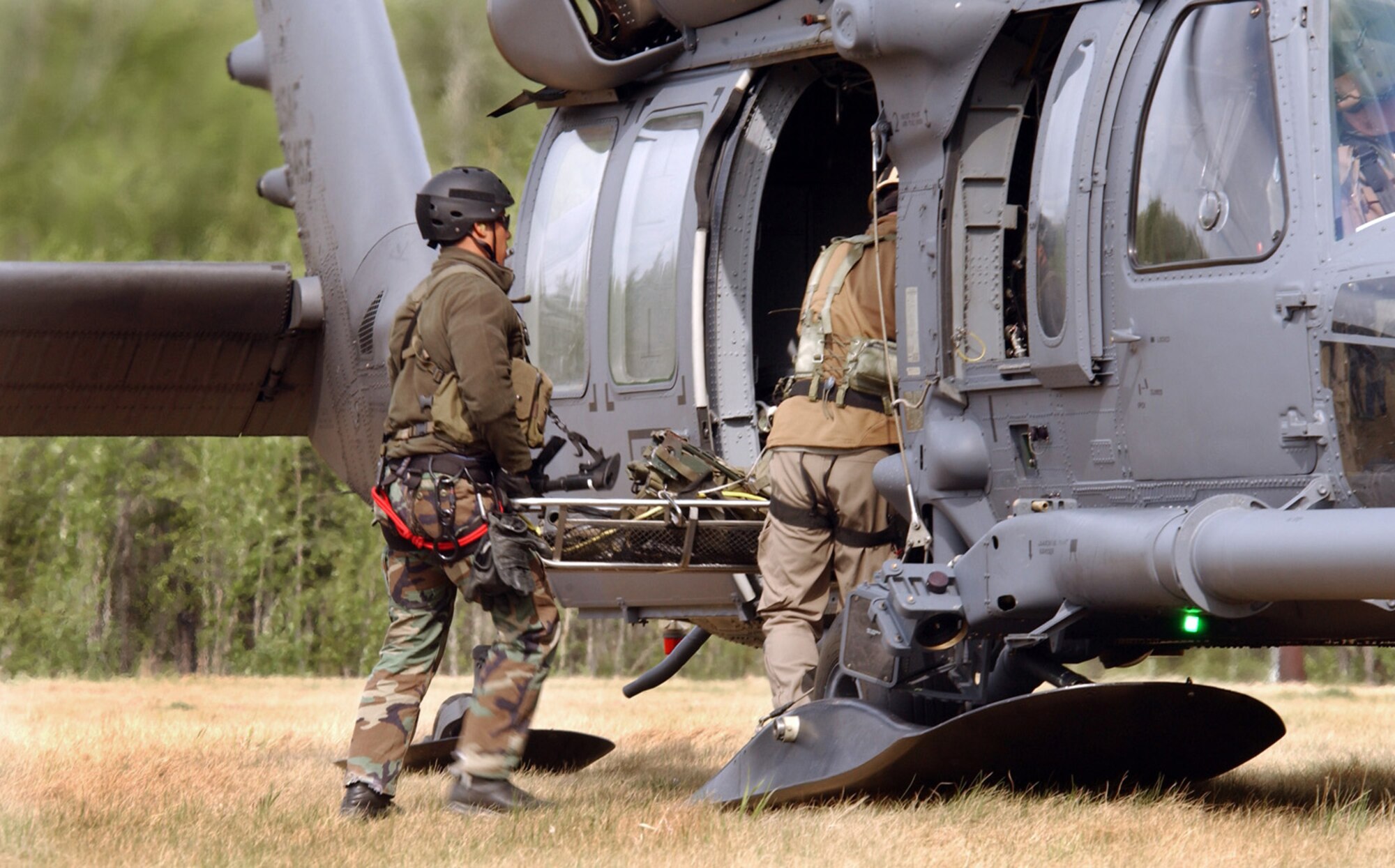 Airmen from the 31st Rescue Squadron at Kadena Air Base, Japan, load a patient onto an HH-60 Pave Hawk during a combat search and rescue mission for exercise Northern Edge 2006 at Fort Wainwright, Alaska, on Tuesday, June 6, 2006. Northern Edge is a joint training exercise hosted by Alaskan Command. It is one of a series of U.S. Pacific Command exercises that prepare joint forces to respond to crises in the Asian Pacific region. (U.S. Air Force photo/Staff Sgt. Joshua Strang) 
