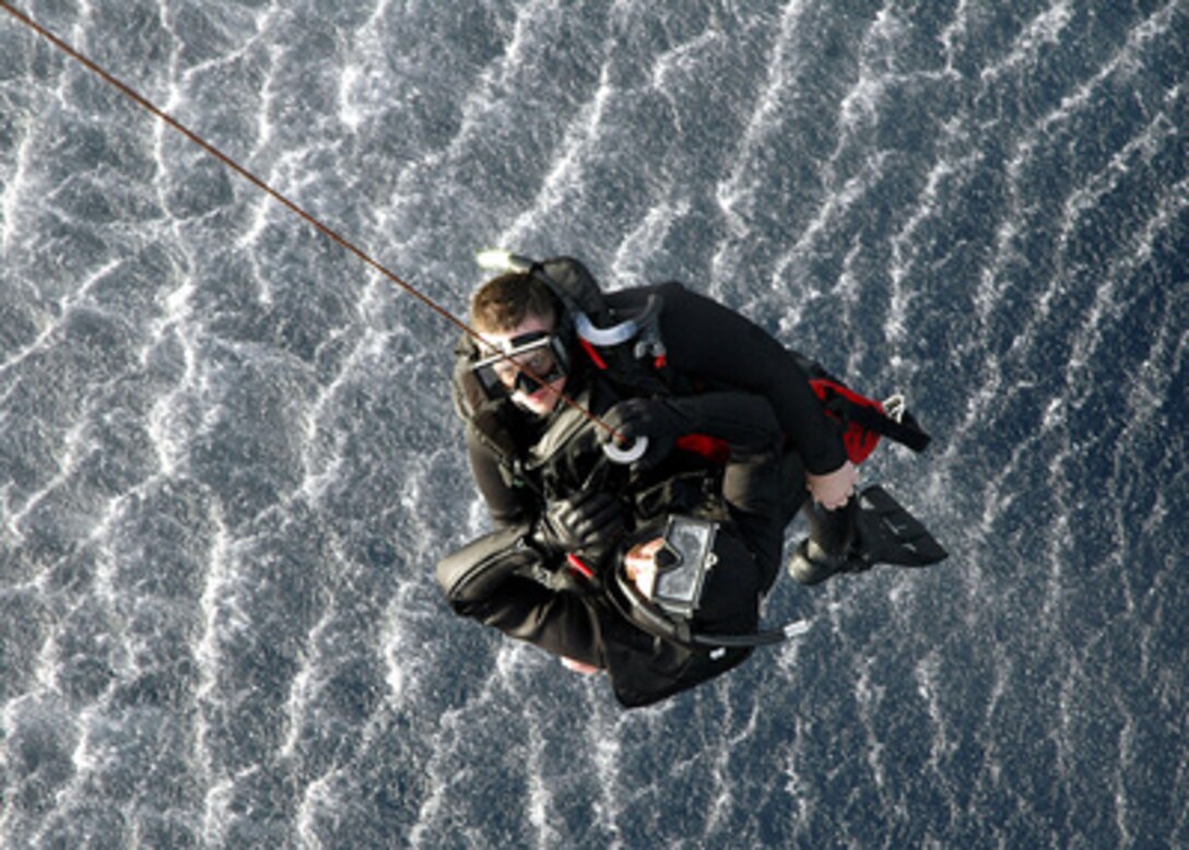 Two U.S. Navy sailors are hoisted into an MH-60S Seahawk helicopter during search and rescue training in the Mediterranean Sea on June 7, 2006. The helicopter and crew are assigned to Helicopter Sea Combat Support Squadron 2, Detachment 4 that is embarked aboard USS Saipan (LHA 2). 